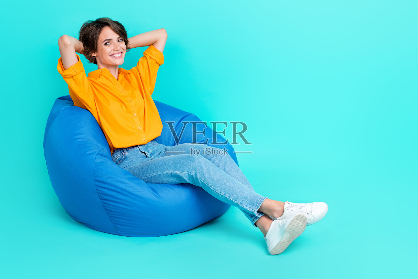 可爱的漂亮女士坐在椅子上,梦想着在水疗酒店度假,享受阳光浴,夏日气息,背景为青色的空旷空间。照片摄影图片