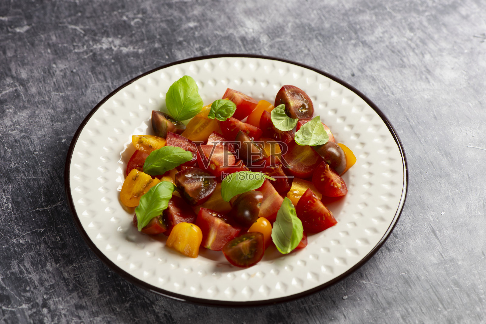 带有罗勒的红色和黄色樱桃番茄沙拉照片摄影图片