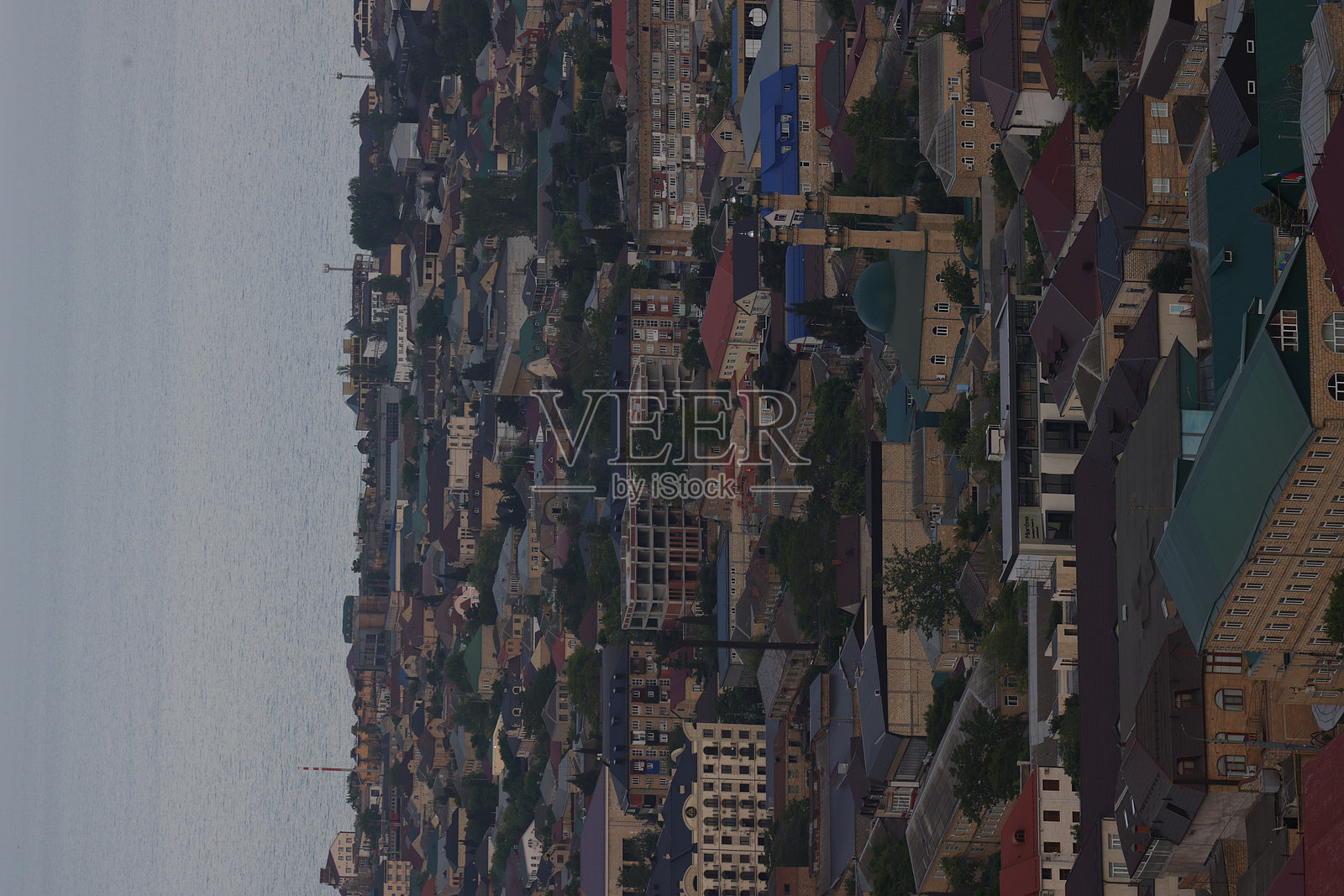 俯瞰黄昏时分繁忙的城市景观,住宅区和靠近水岸的钟楼尽收眼底照片摄影图片