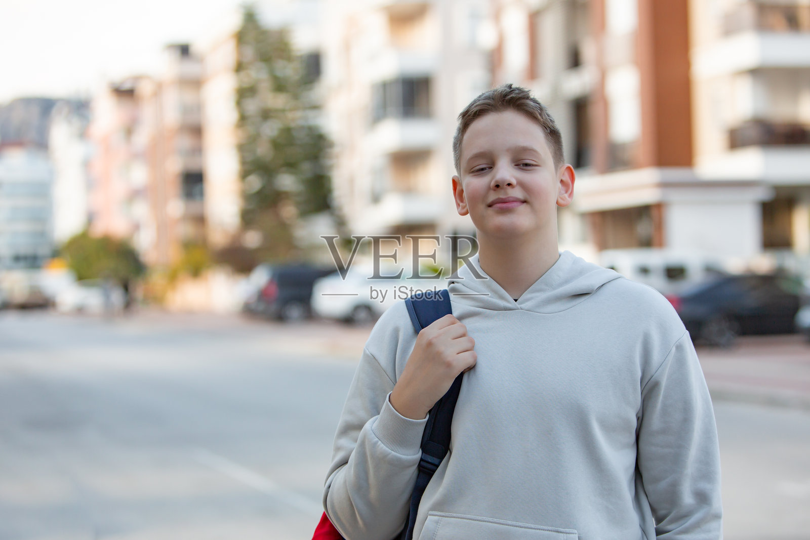 阳光明媚的下午,城市中微笑的青少年准备上学照片摄影图片
