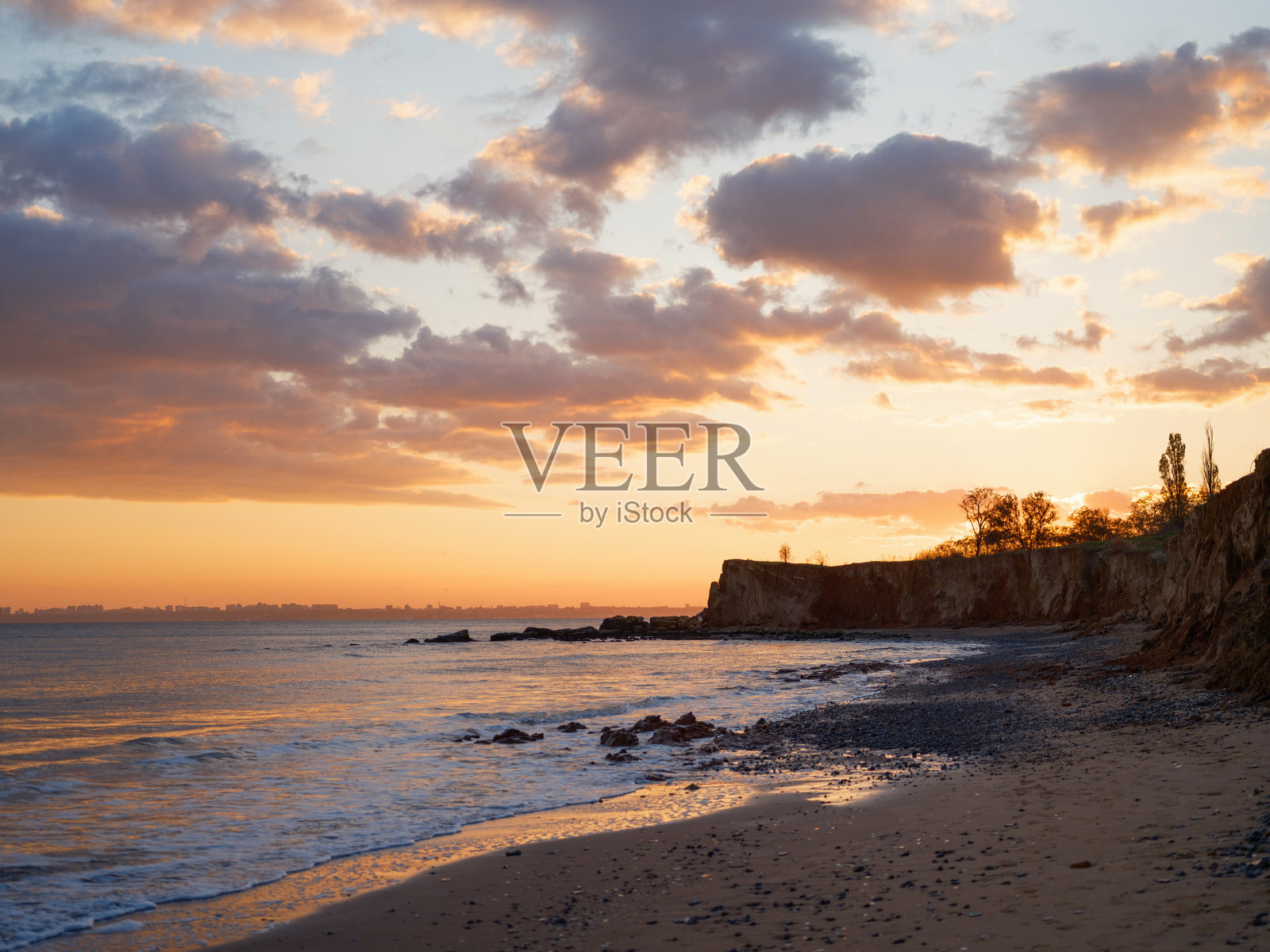 黑海海岸日落时美丽的海景,岩石与迷人的云彩。照片摄影图片