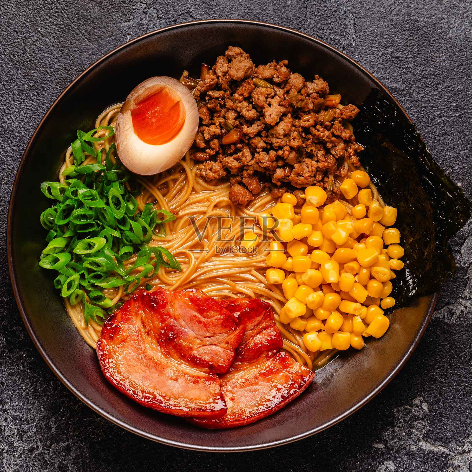 一碗包含面条、肉和葱的拉面。照片摄影图片