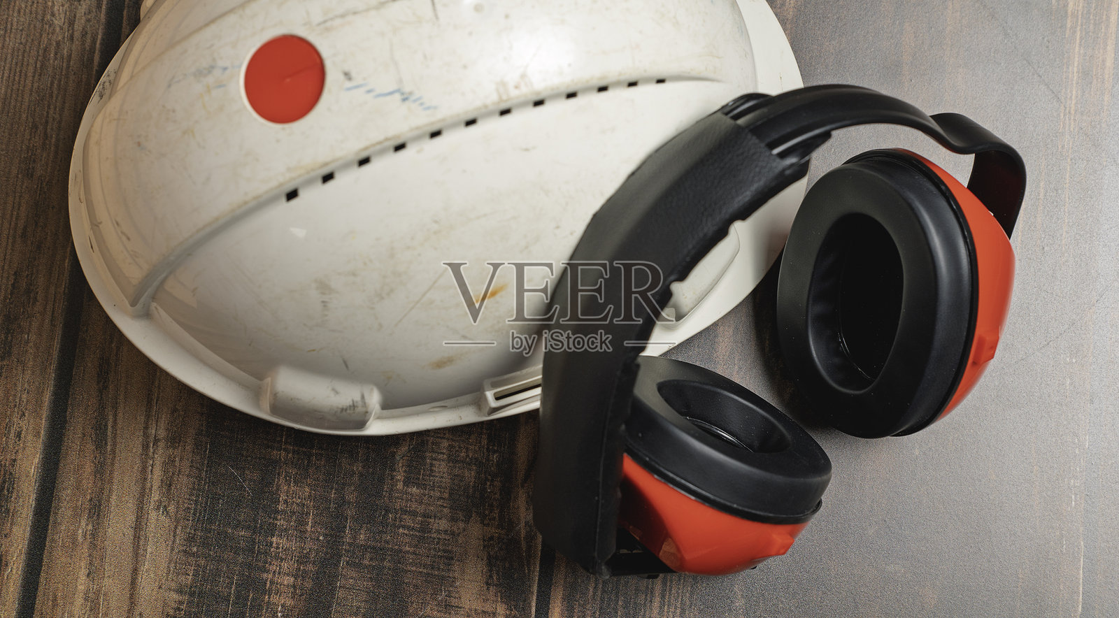 红色安全耳机和白色安全帽。照片摄影图片