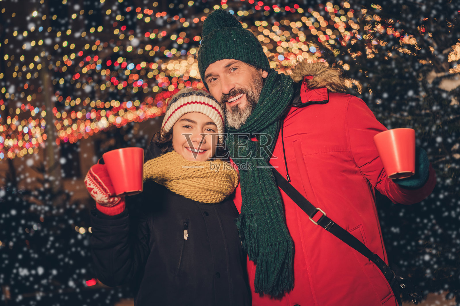 吸引人的快乐人们的肖像,最好的朋友,单身父亲抱着儿子,代际价值观,喝着可可,城市户外。照片摄影图片