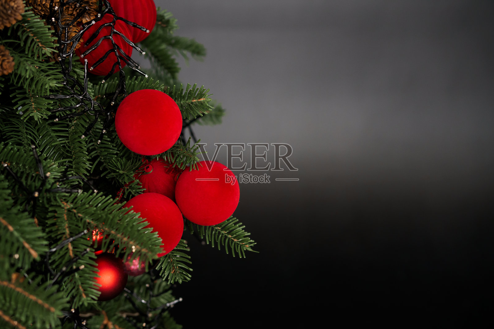 节日气氛中的红色装饰品特写,背景为深色圣诞树照片摄影图片