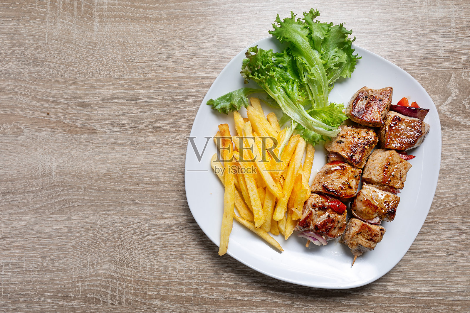 希腊美食:串烧肉与沙拉盛在盘子里照片摄影图片