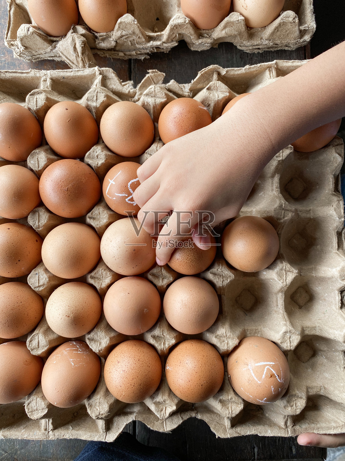 男孩的手和市场上的一组鸡蛋照片摄影图片