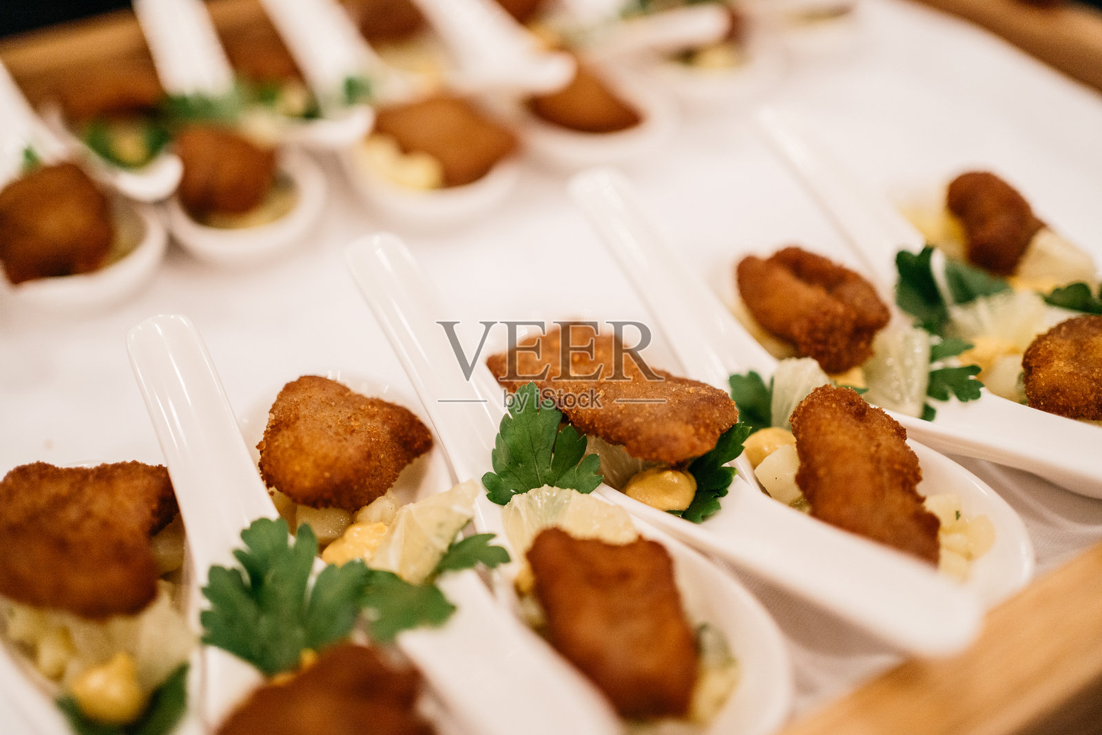 迷你炸肉排开胃菜配土豆沙拉,盛放在品尝勺上照片摄影图片