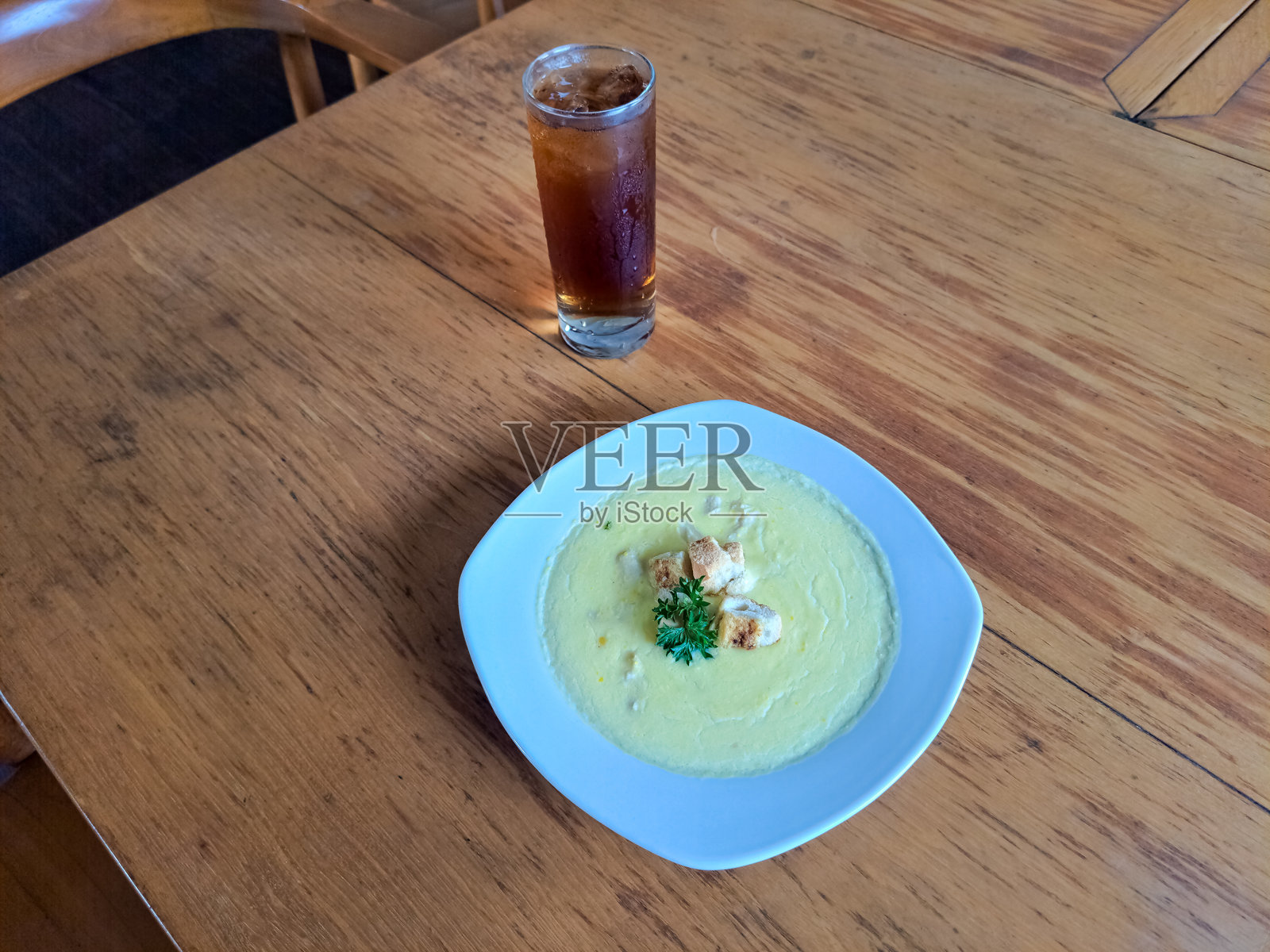 玉米汤配烤面包丁和香 parsley。新鲜茶水冰镇在玻璃杯中。食品和饮料菜单。照片摄影图片