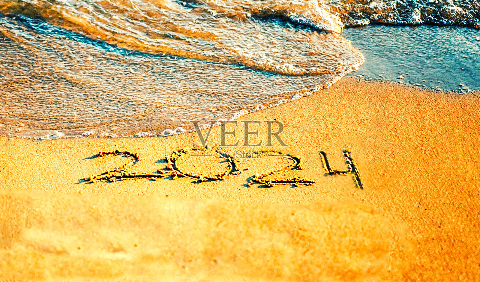 海边沙滩上的“2024”字样。海浪。即将过去的2024年。照片摄影图片