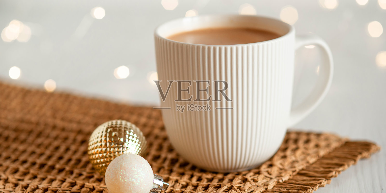 一只白色杯子里装着热咖啡或茶,放在白色木桌上。照片摄影图片