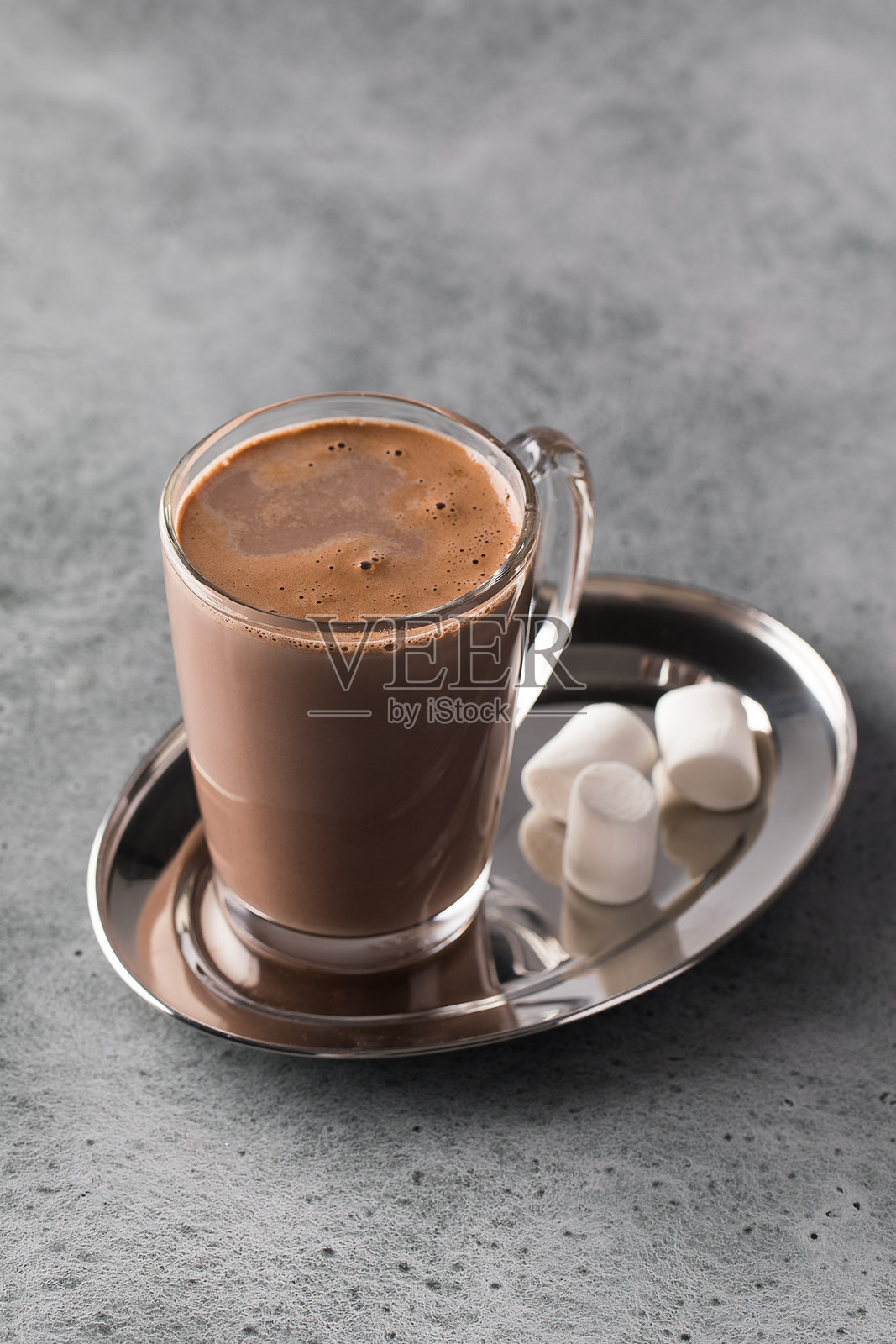 一杯丰富的热巧克力,上面放着棉花糖,摆放在银色托盘上。照片摄影图片