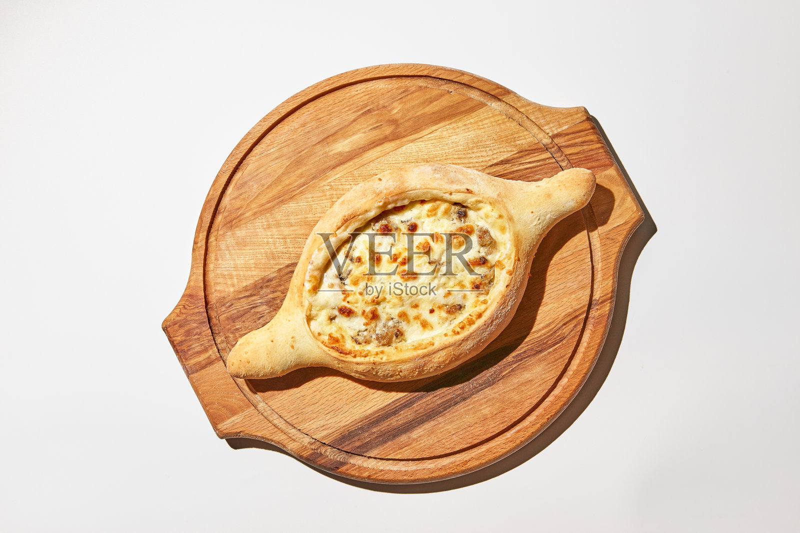 白色背景上的阿贾里干哈恰普里。这是一种不传统的格鲁吉亚美食,面团船里装有奶酪和肉。照片摄影图片