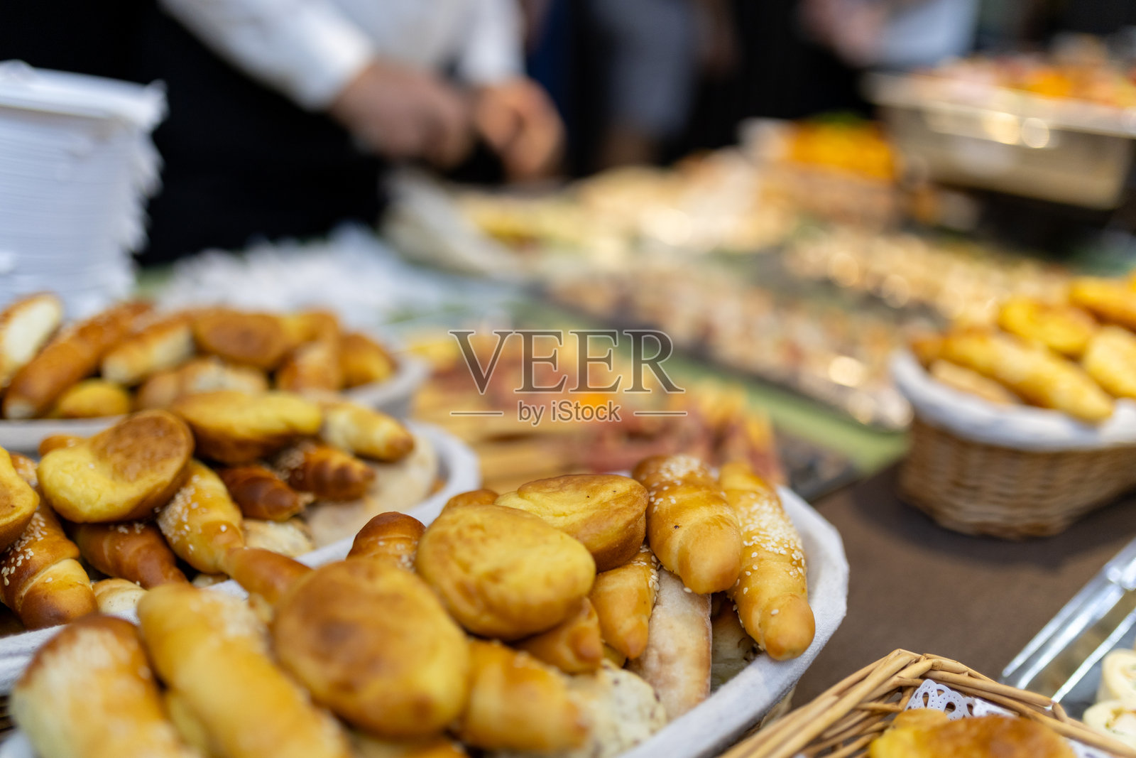 下午时分,热闹的当地市场上陈列着各式新鲜出炉的面包卷和糕点。照片摄影图片