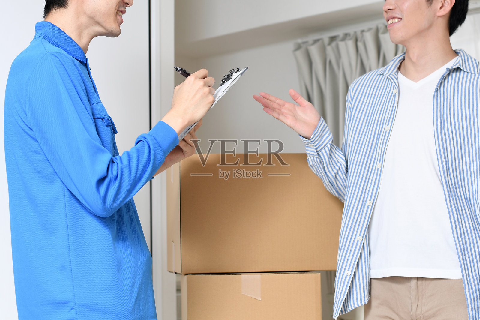 一名男性工作人员与一名年轻男性顾客在房间里交谈照片摄影图片