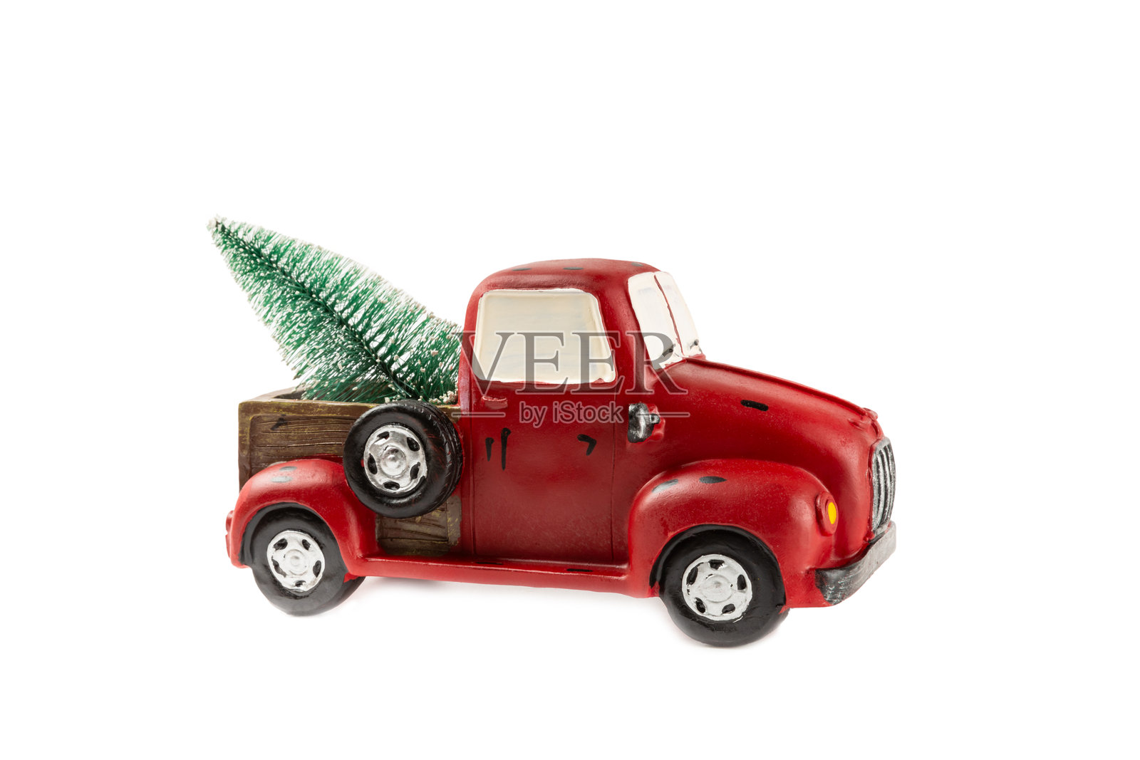 白色背景上的圣诞小车。玩具车上载着圣诞树,车上覆盖着雪。圣诞背景。节日贺卡。照片摄影图片