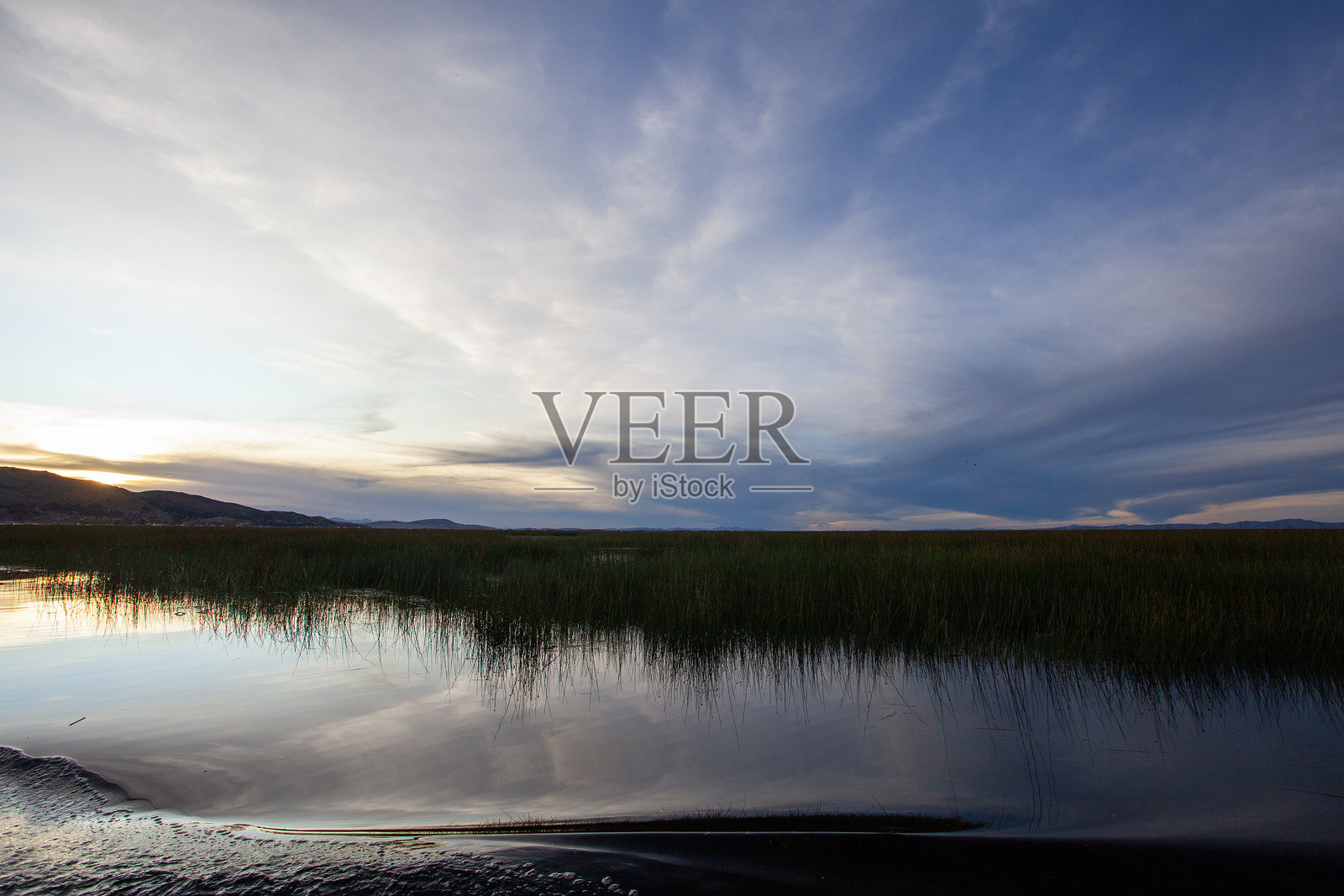 美丽的的的喀喀湖和安第斯山脉在日落时分的景色,拍摄于从秘鲁普诺出发的游船上。照片摄影图片