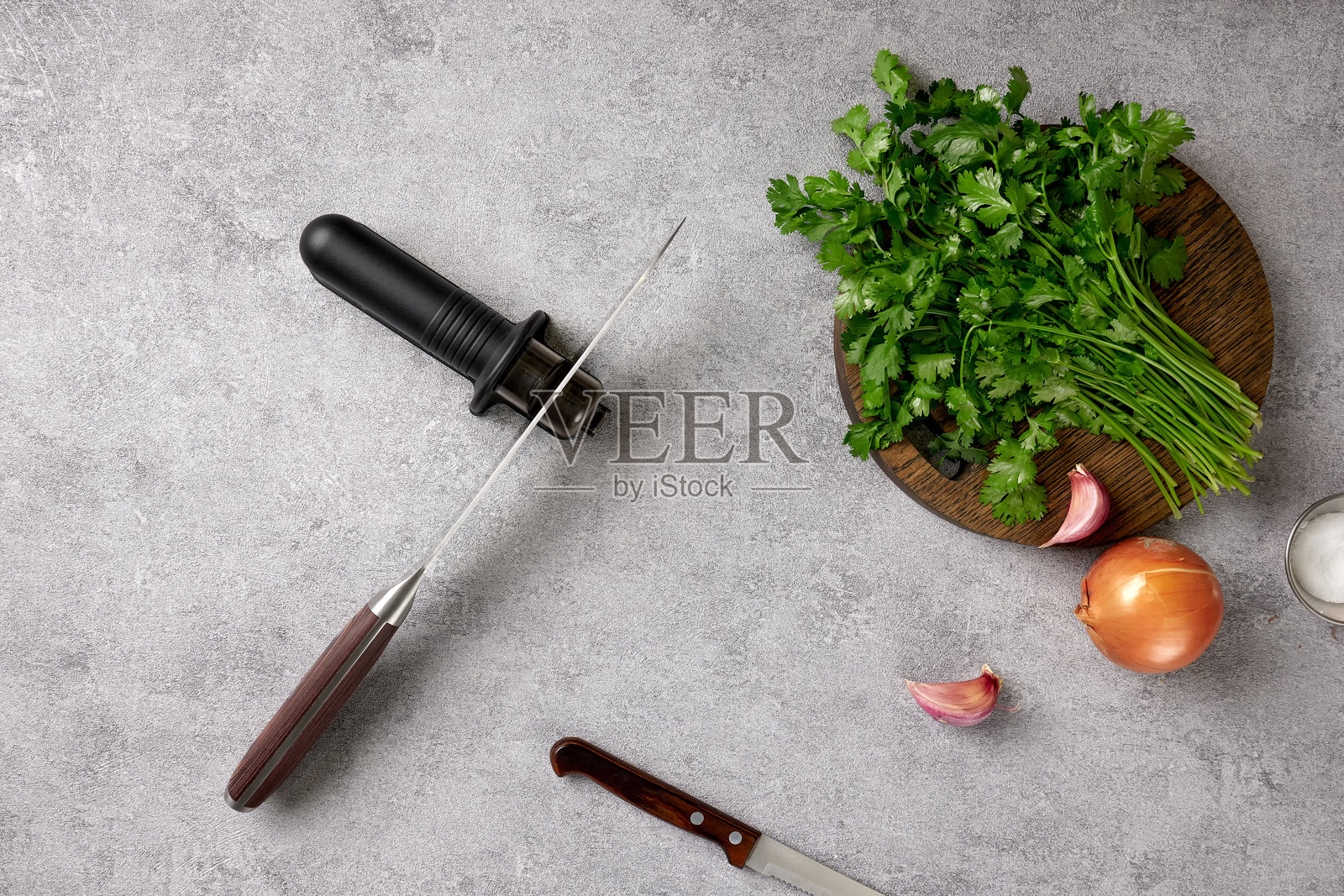 家庭厨房桌子上的厨房刀具和手动磨刀器特写。照片摄影图片