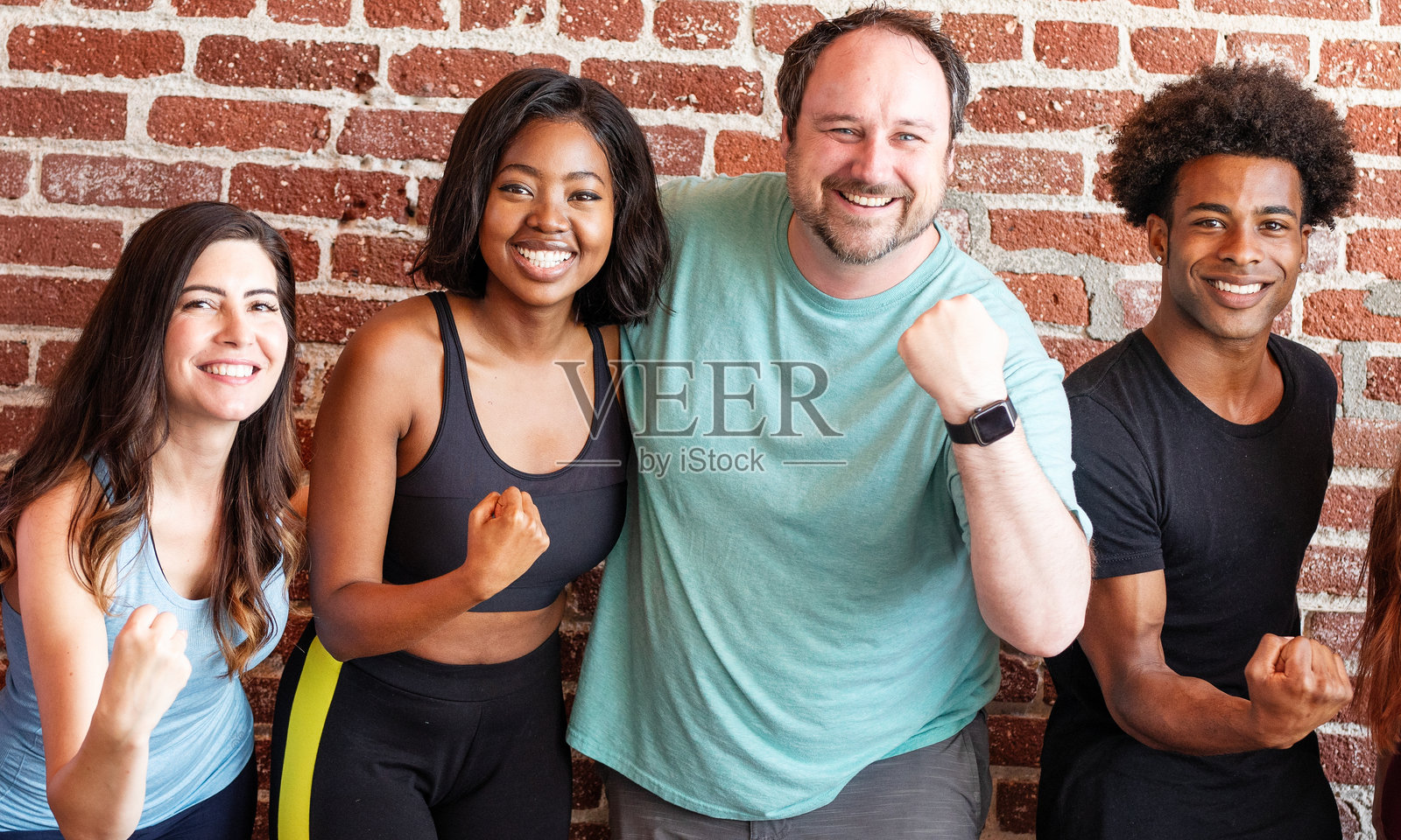 多元化的男女群体,穿着运动服,包括非裔美国人、白人和西班牙裔。照片摄影图片