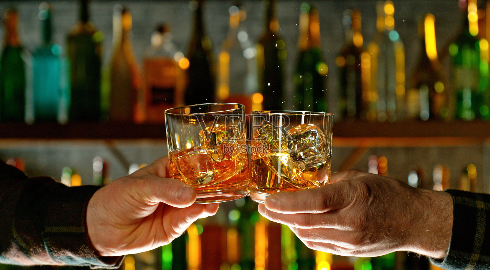 手中握着两杯威士忌的特写镜头。照片摄影图片