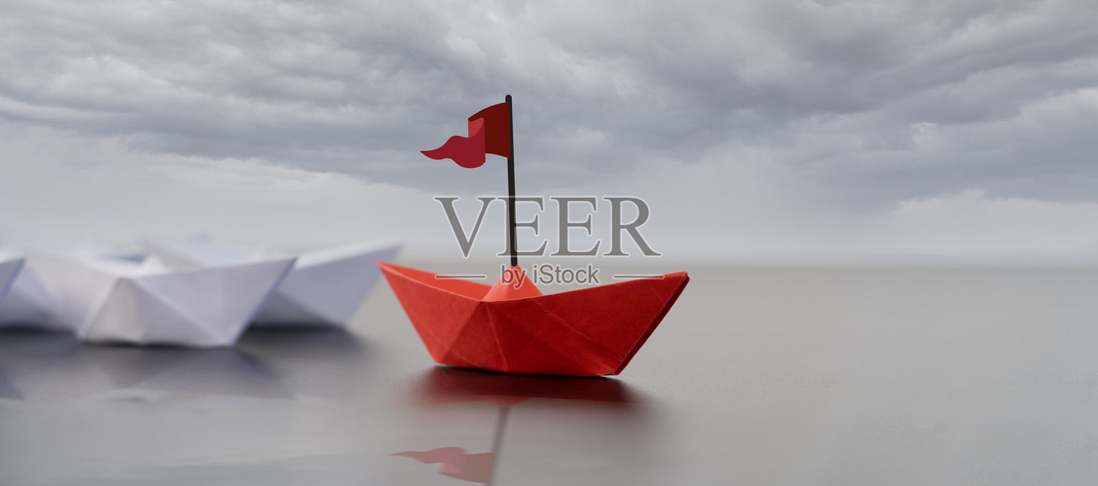 领导力概念与纸船。黑色背景上的一组彩色折纸船。商业竞争。照片摄影图片