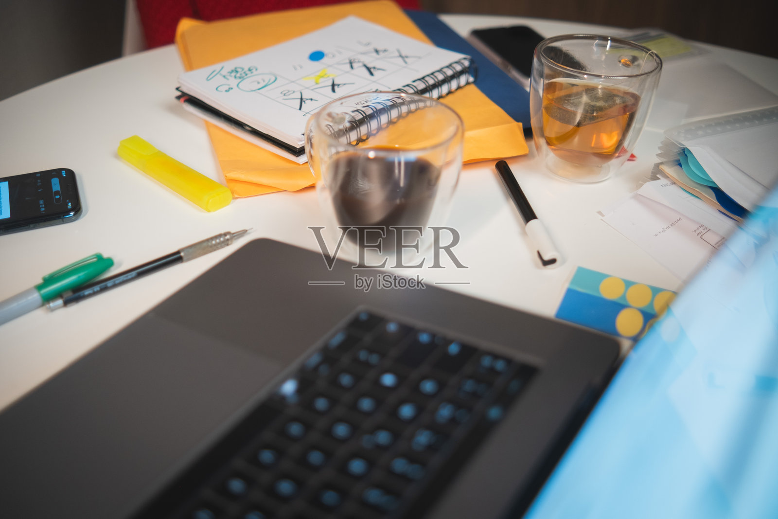 一台笔记本电脑放在桌子上,旁边有一杯咖啡和一本笔记本。照片摄影图片