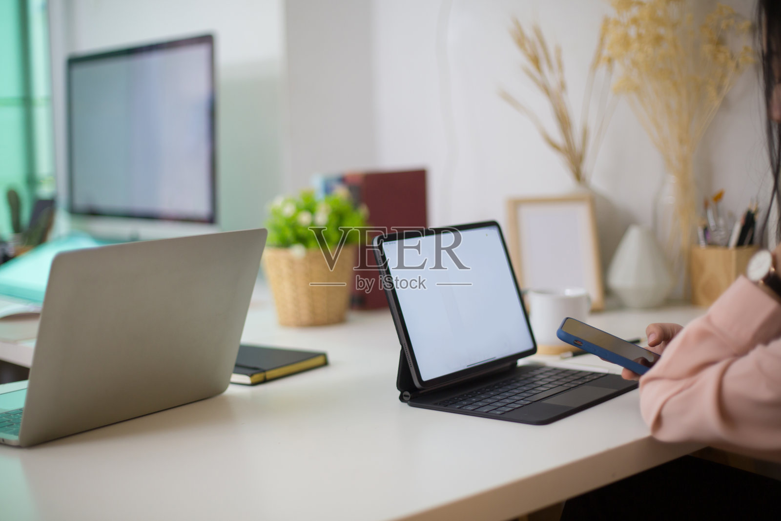 特写镜头,商务女性的手正在用笔写字,旁边有电脑。照片摄影图片