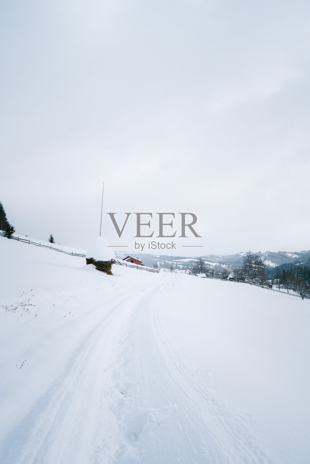 冬季山地风景中通往乡村住宅的雪覆盖小径照片摄影图片