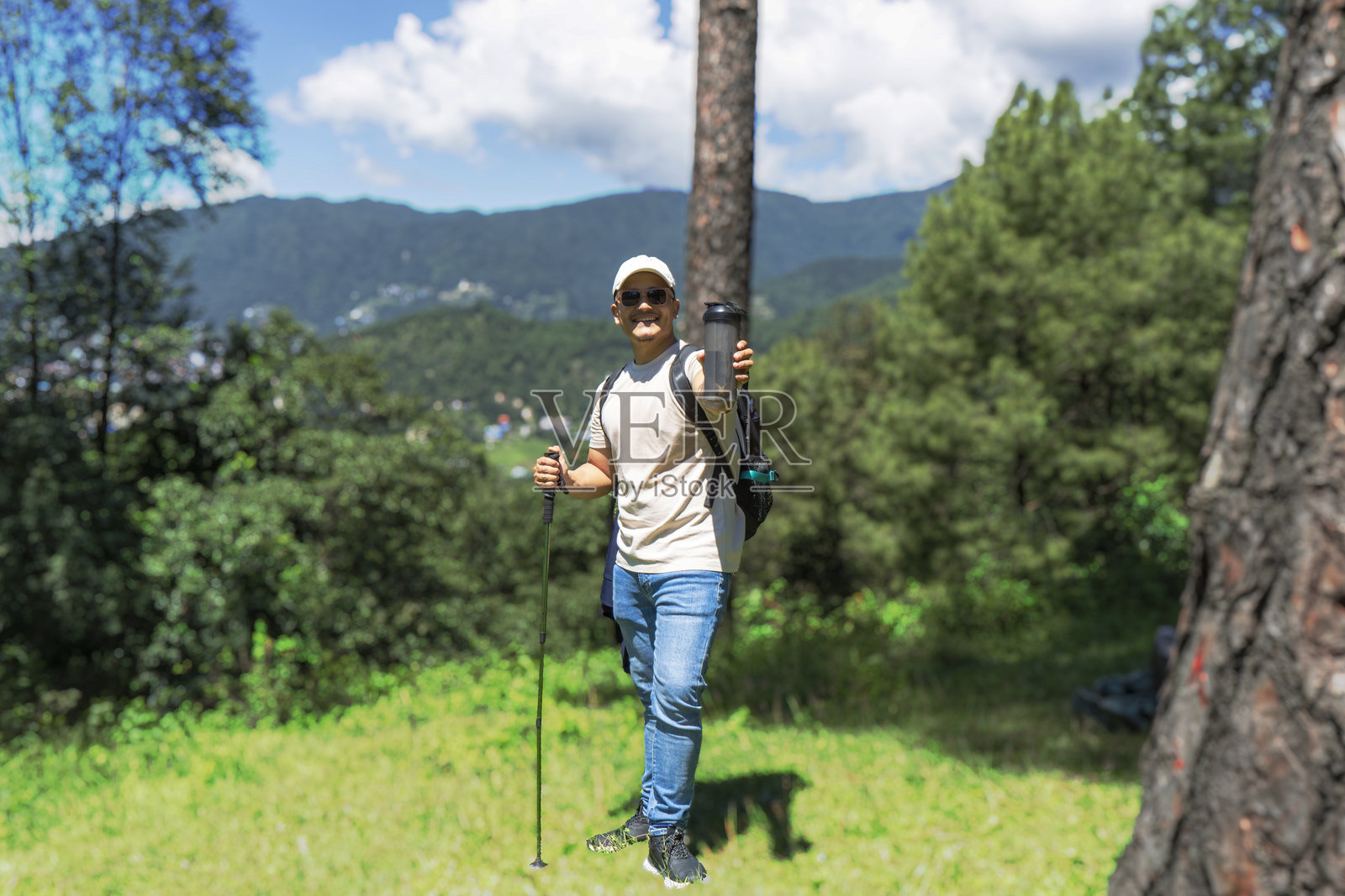 健壮年轻男性徒步旅行者在自然森林中与狗一起,开心地做出手势照片摄影图片