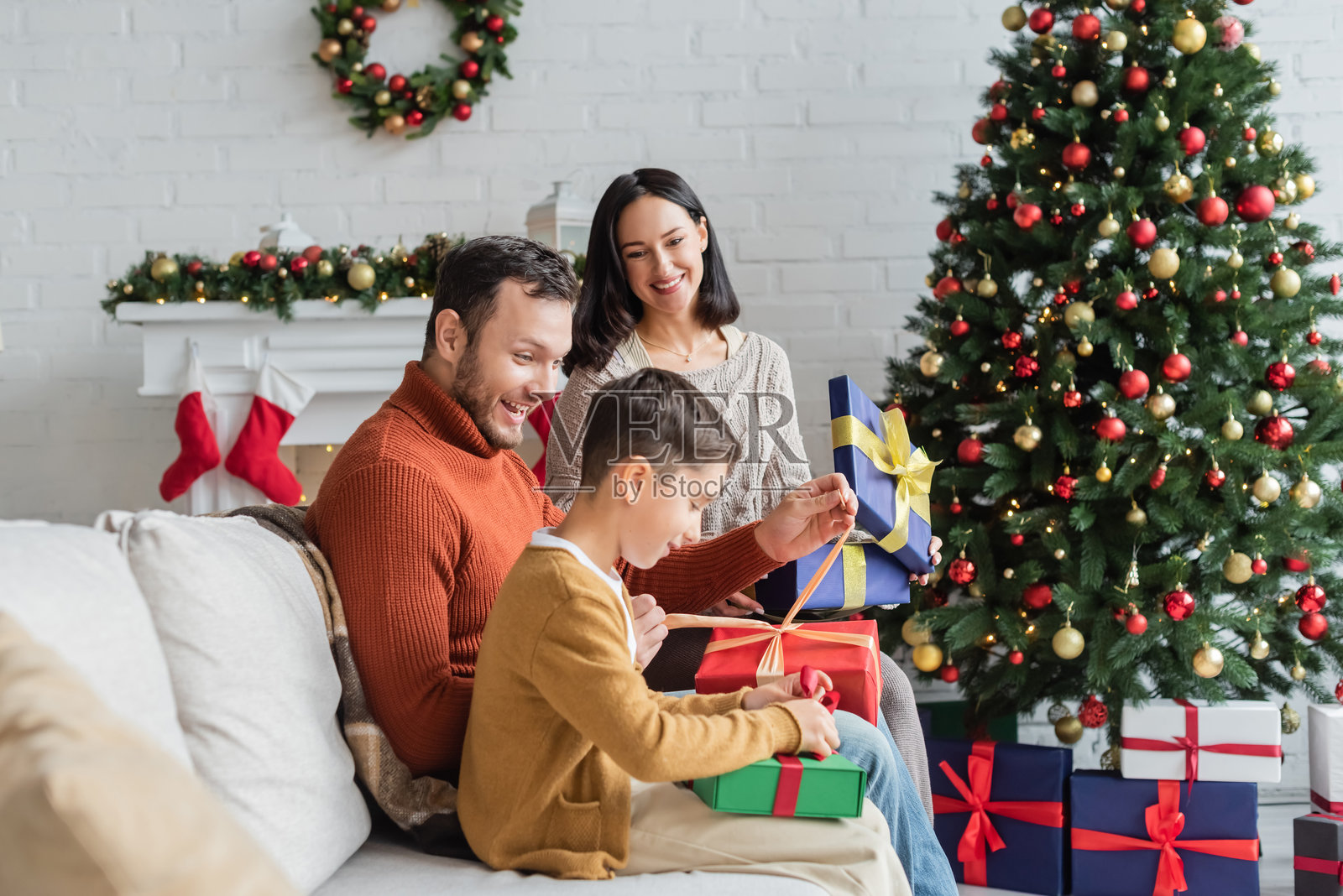 快乐的家庭在温馨装饰的现代公寓里一起庆祝圣诞节照片摄影图片