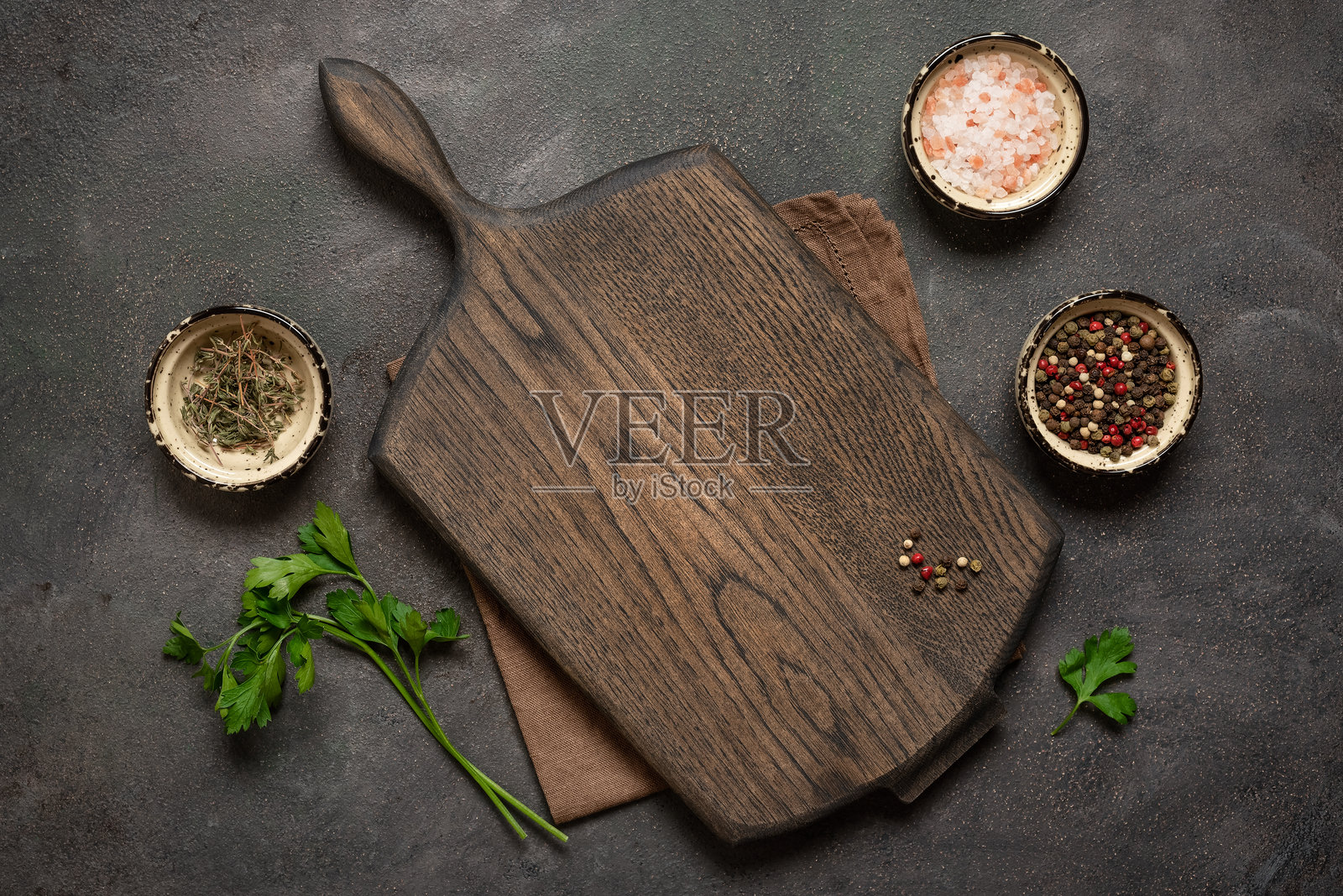 烹饪背景,空的木质切菜板,香料,亚麻餐巾,香 parsley,深色粗糙背景。俯视图,平铺,留白空间。照片摄影图片