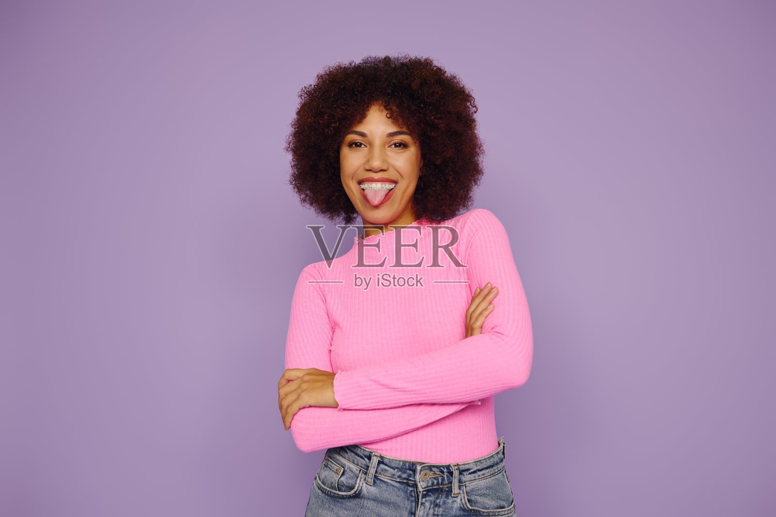 快乐的年轻黑人女性,卷发,俏皮地在摄影棚中摆姿势照片摄影图片