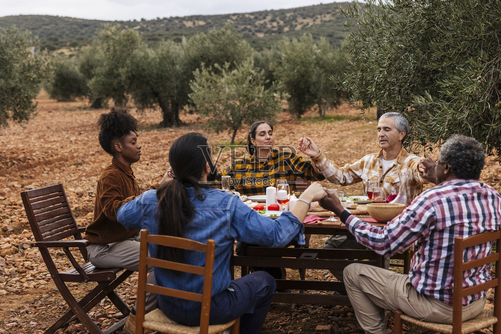 农民们在橄榄树林中一起用餐前祈祷照片摄影图片