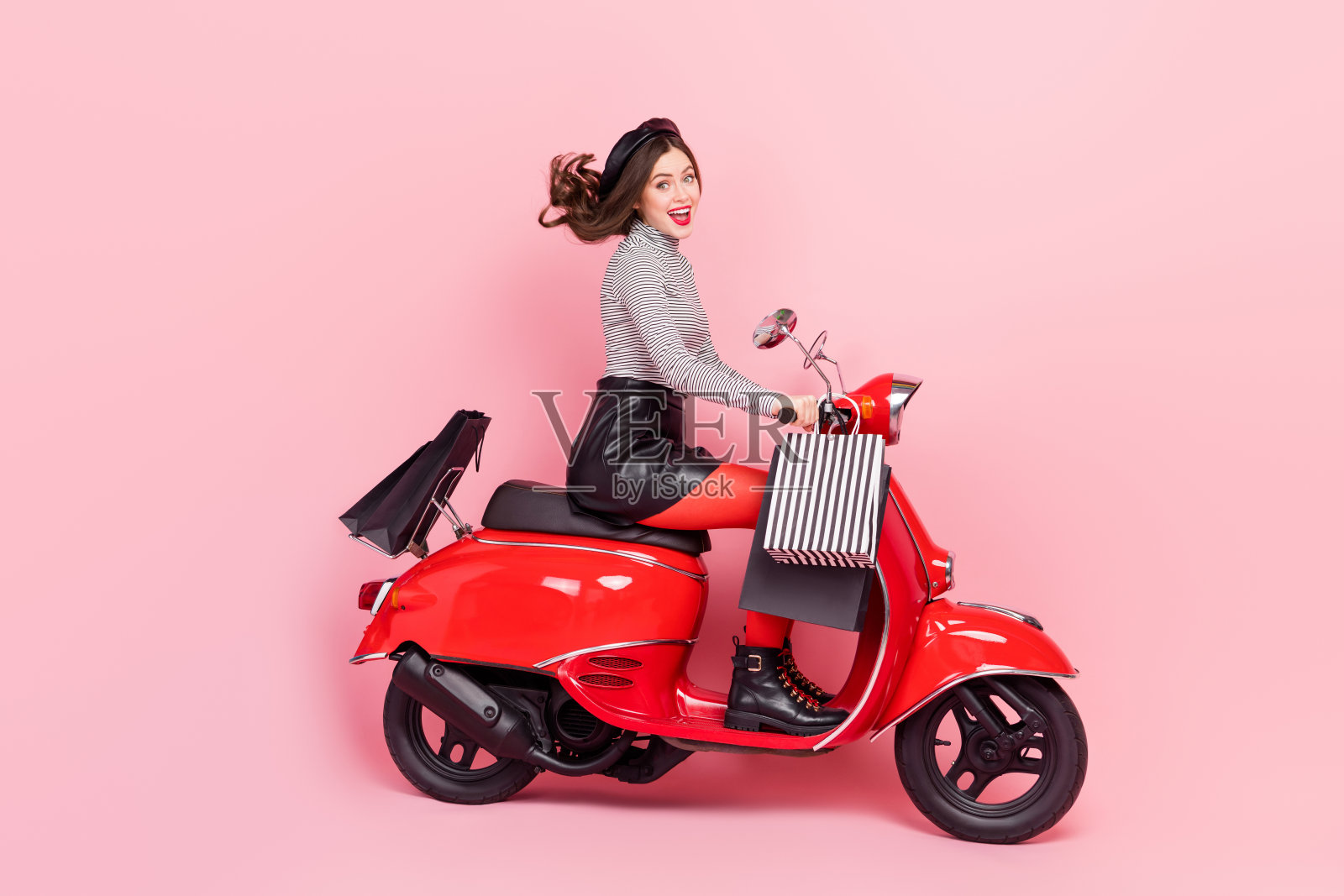 极限摩托车女司机的侧面个人资料照片,骑行商店时尚购物优惠,背景为粉色。照片摄影图片