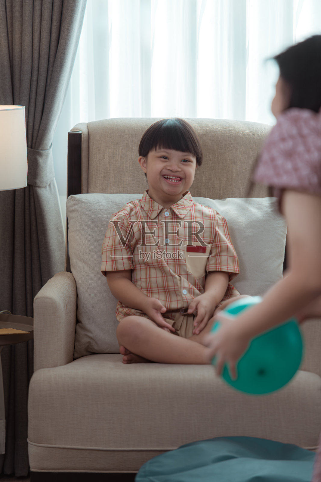 一个特殊的孩子在家里的客厅沙发上放松。照片摄影图片