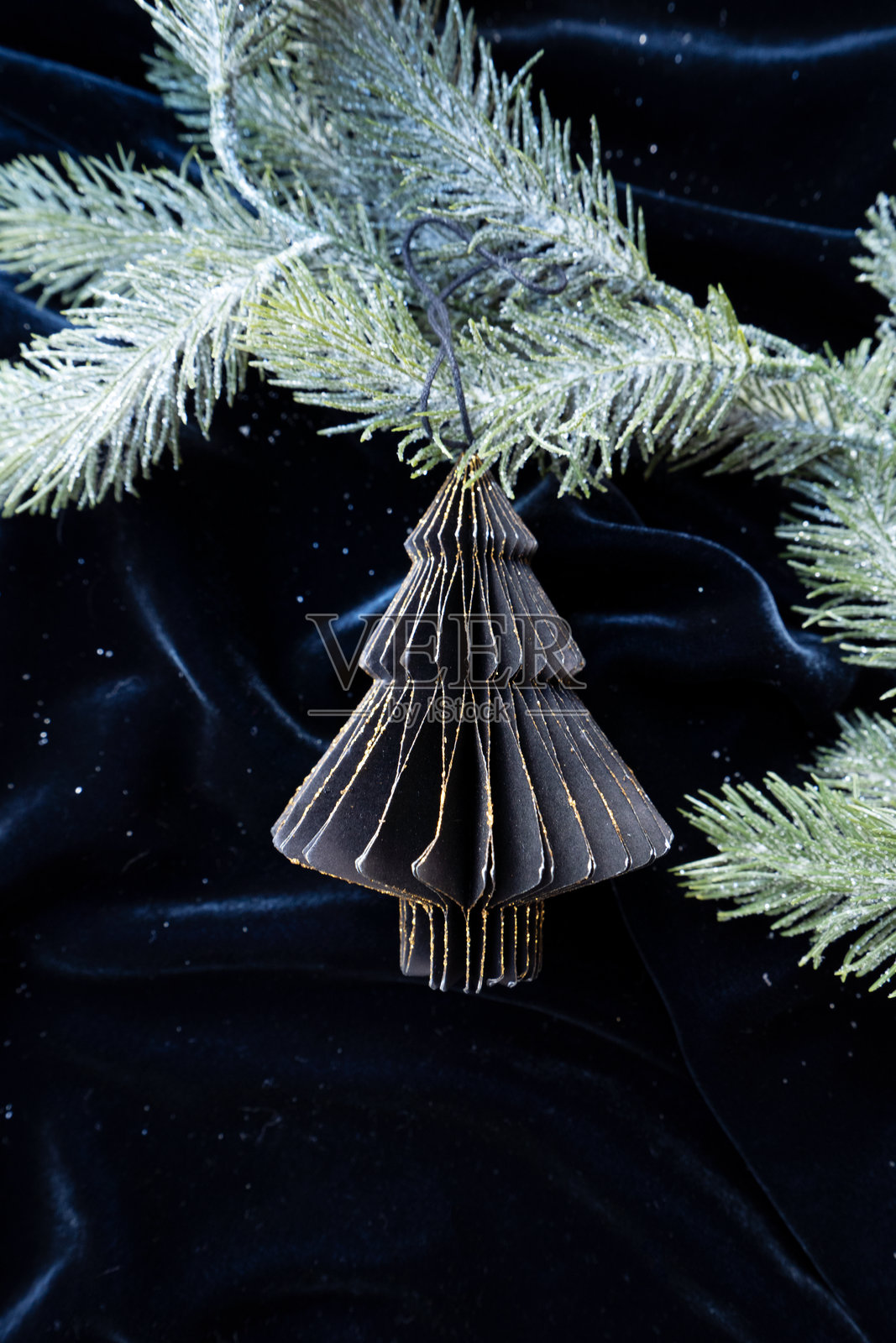 一个装有复古圣诞装饰品的盒子展示在银色布料背景上,营造出节日的氛围。照片摄影图片