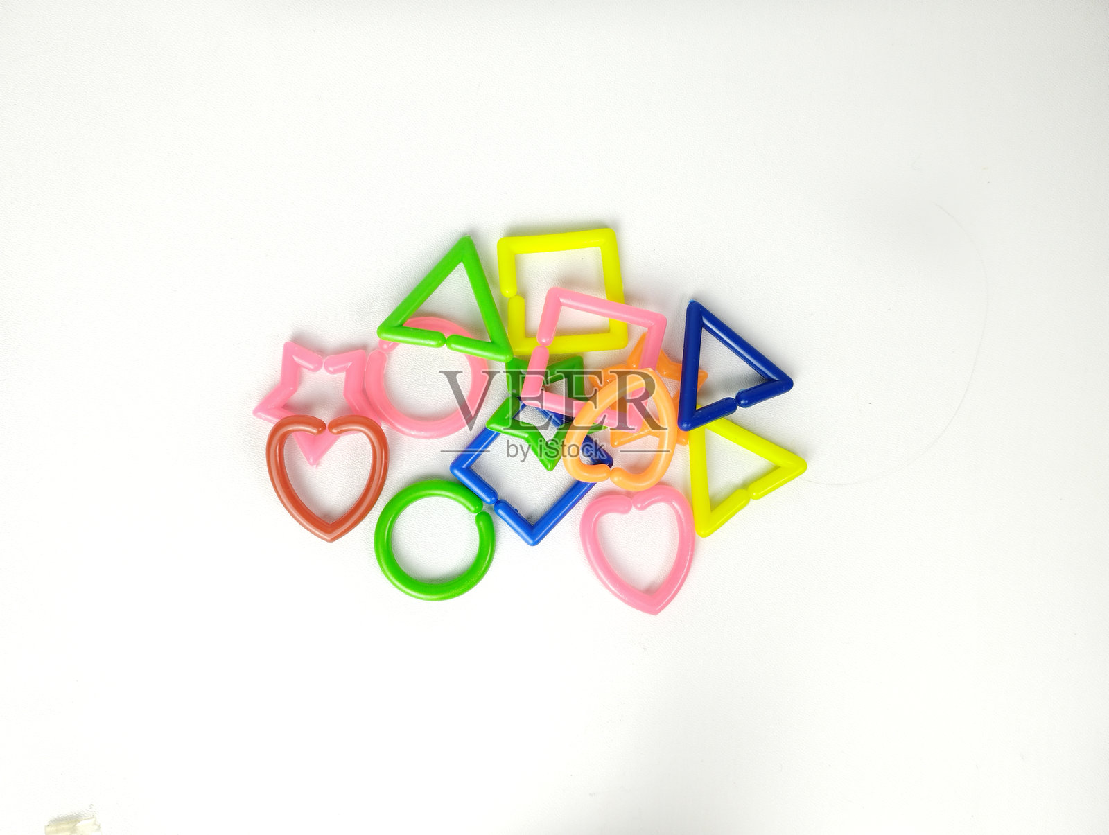 教育玩具,认知技能,儿童发展。色彩丰富的蒙特梭利几何形状玩具,孤立在白色背景上。包括正方形、三角形、星星、圆形和心形。照片摄影图片