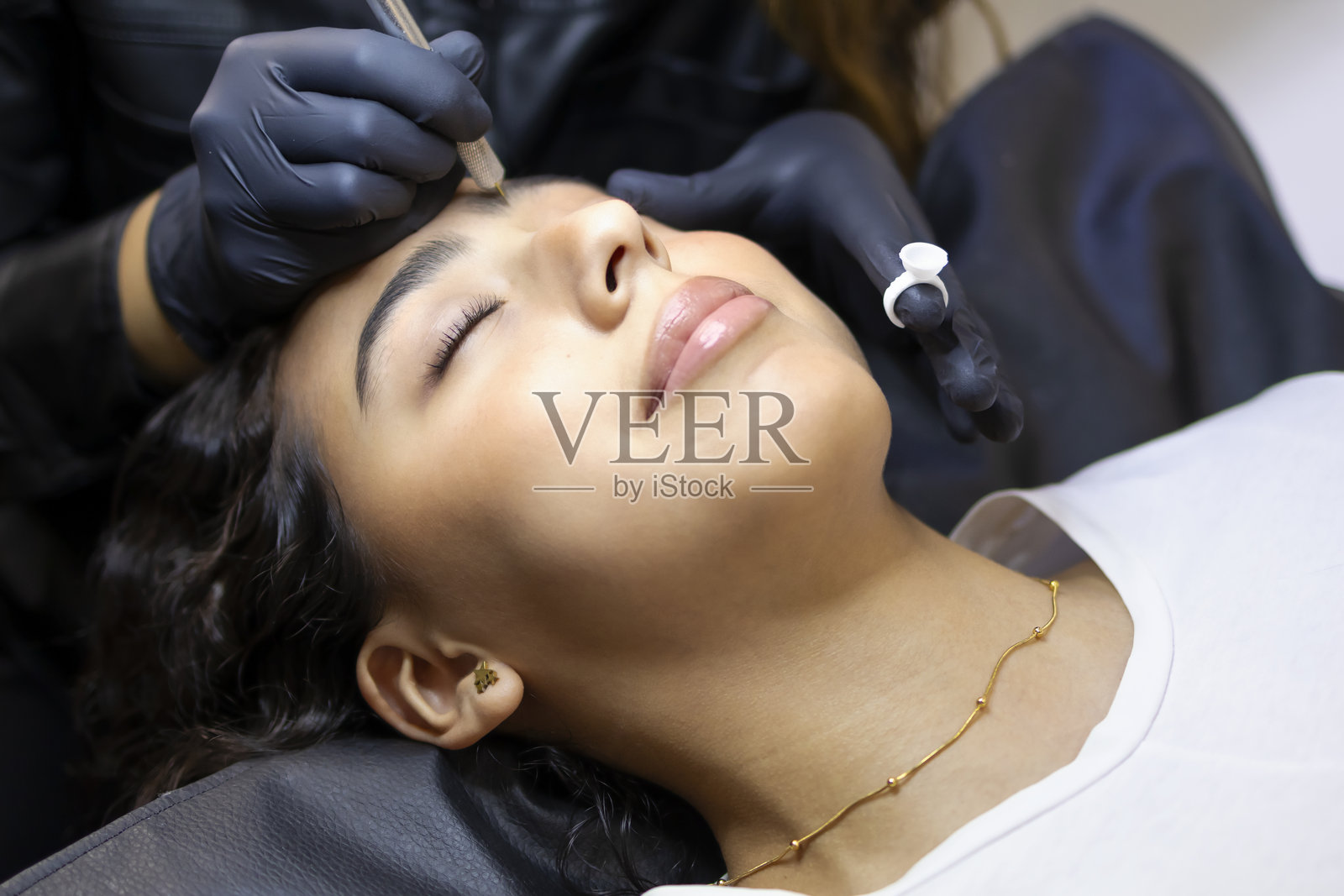 为女孩修整眉毛的造型师照片摄影图片