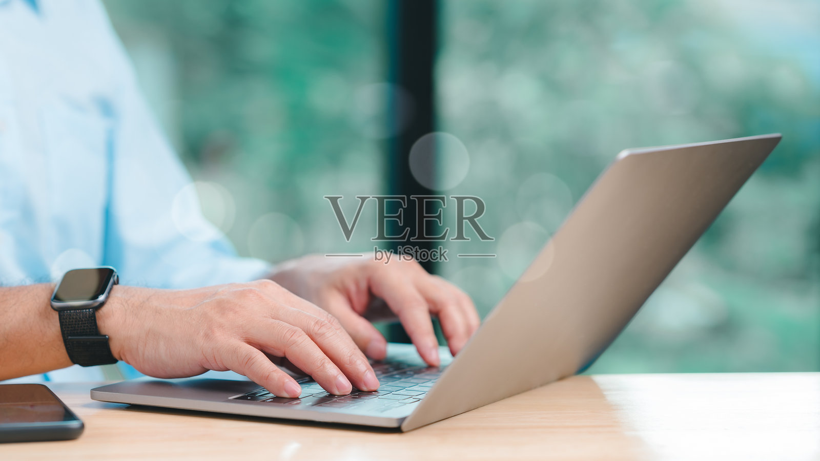 在宁静的环境中,特写镜头展示双手在笔记本电脑上打字,体现现代科技与生产力的结合。场景突显了数字设备在日常生活中的融入。照片摄影图片