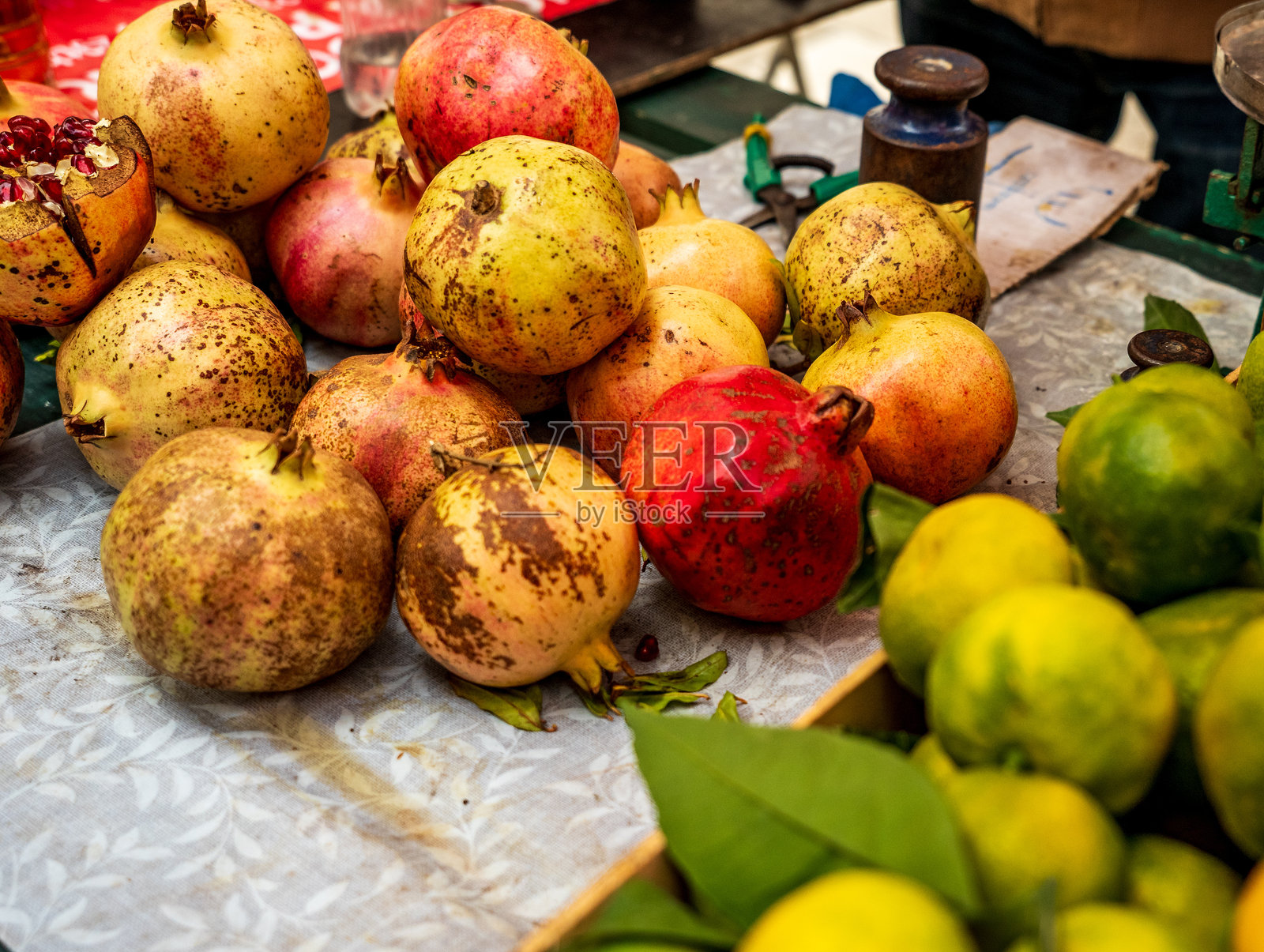 杜布罗夫尼克 - 克罗地亚 - 2024年10月18日 一个充满活力的市场摊位展示了新鲜的乡村石榴和绿色柑橘水果。色彩和质感突显了当地农产品的自然魅力。照片摄影图片
