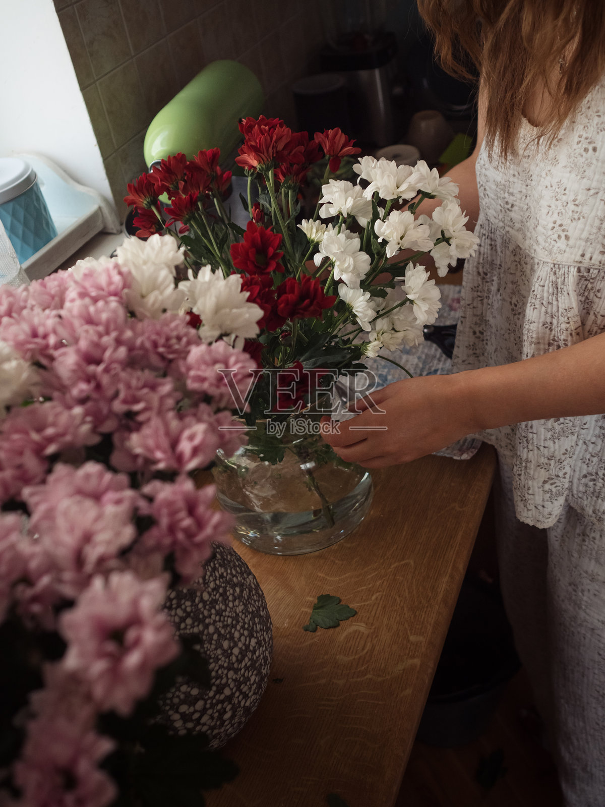 周末早晨:在厨房桌子上整理菊花花束,垂直特写照片摄影图片