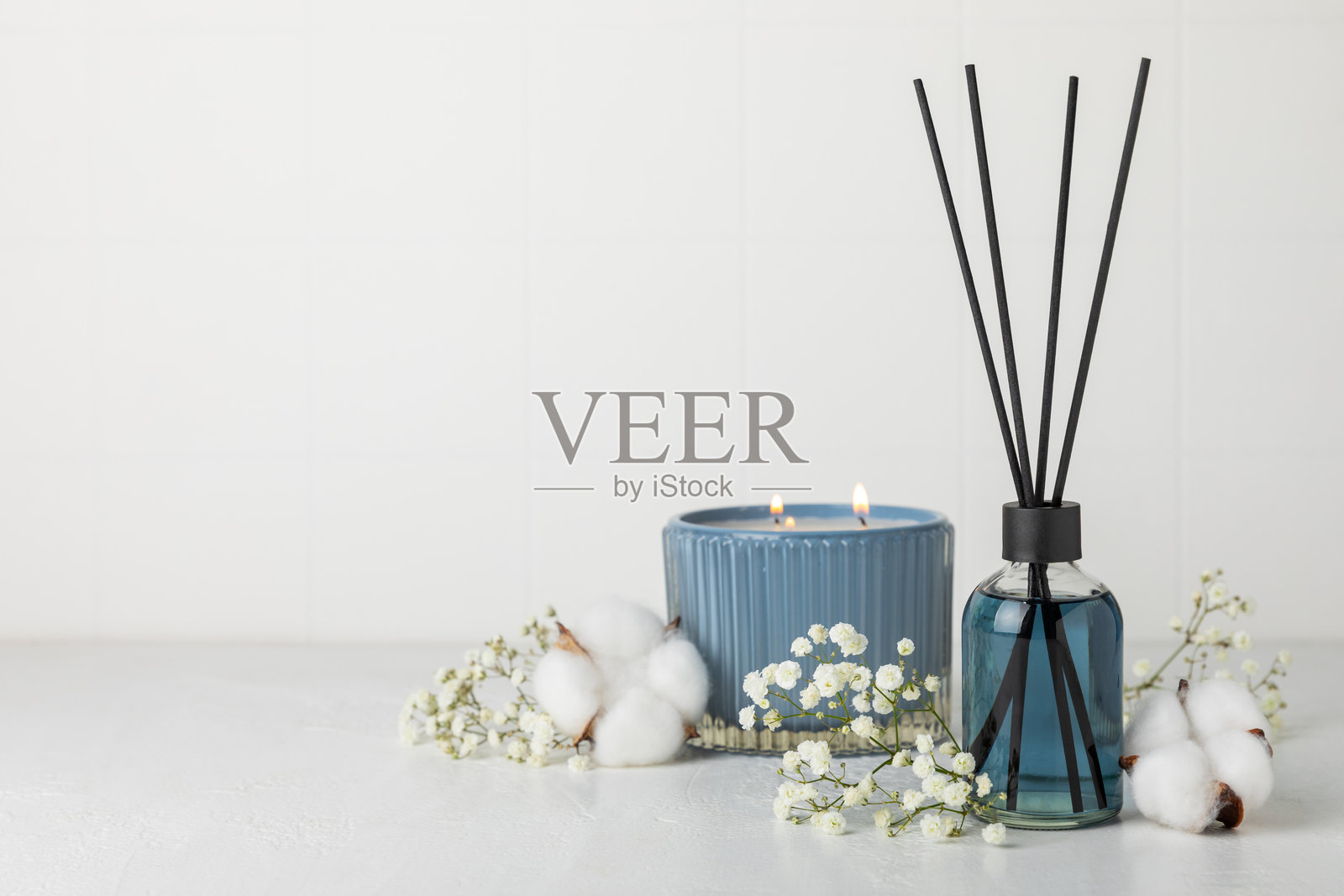 木桌上的芳香藤条空气清新剂。具有天然水果、花香和香料香气的扩散器。室内香氛。奢华的家用香水。橙子、青柠、咖啡、肉桂、八角、香草和兰花。照片摄影图片