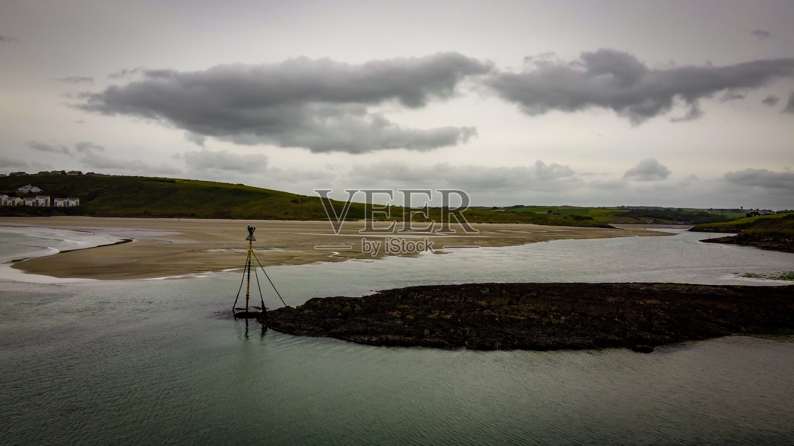 海泥,阴云密布的夏日海滩。退潮时,水体在阴云的天空下。照片摄影图片