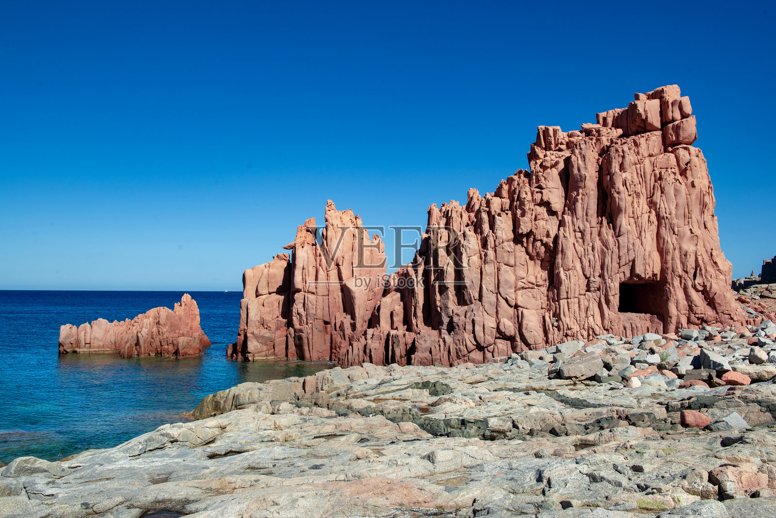 撒丁岛意大利的红色花岗岩岩石与水晶般的海洋相接 - Rocce Rosse Arbatax照片摄影图片