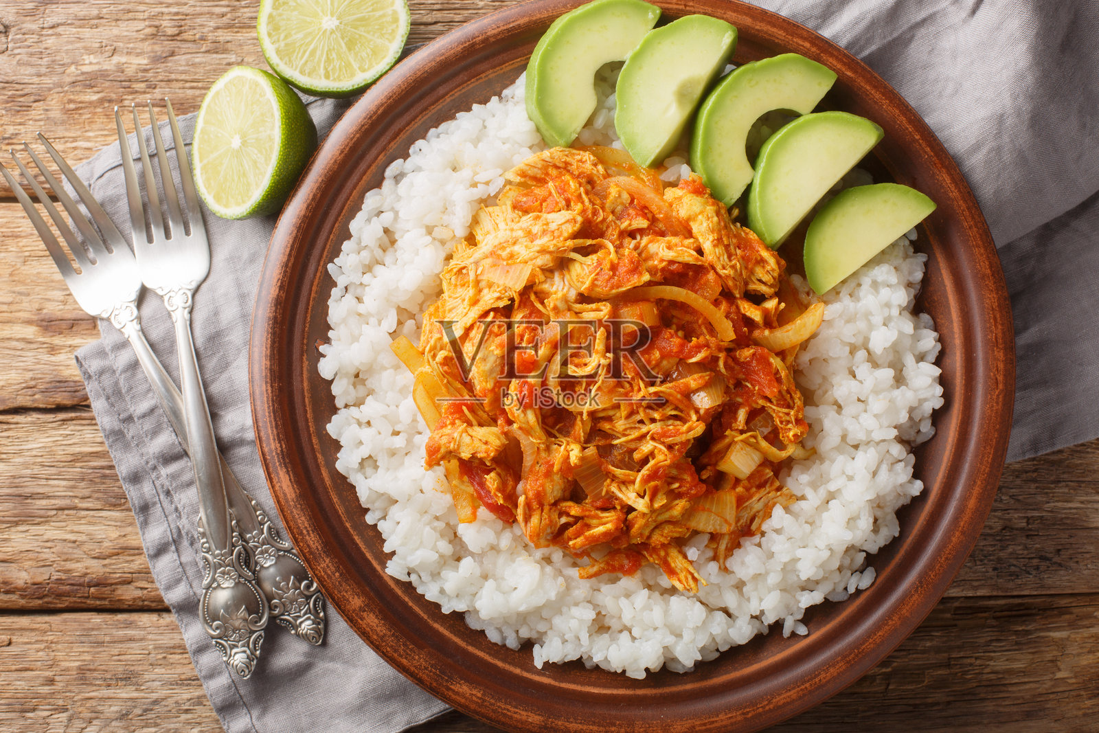 特制的丁加鸡肉,调味料为塔可调料,炖煮在高汤中,搭配米饭和鳄梨,特写在盘子里。横向俯视。照片摄影图片