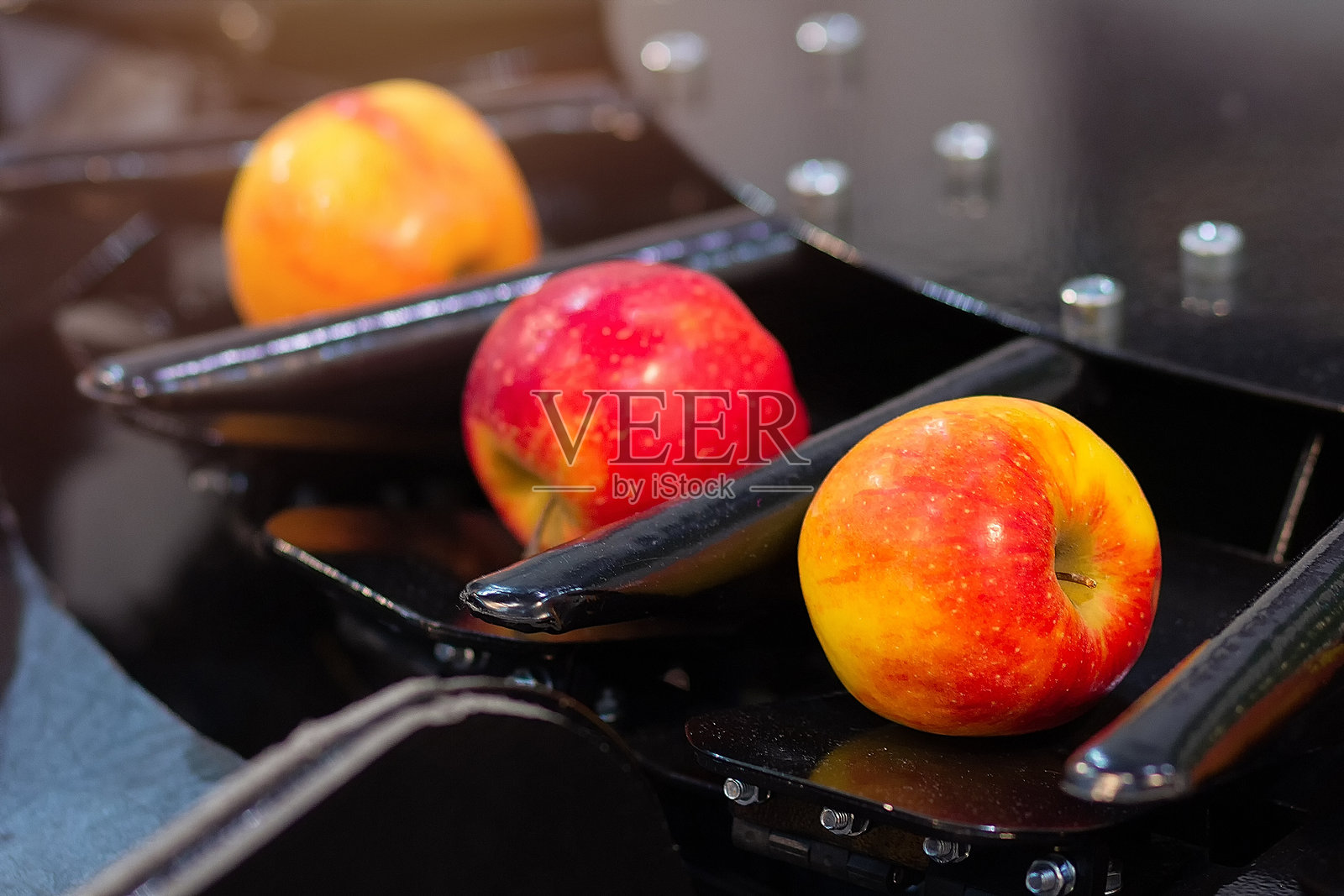 传送带上,新鲜苹果在工厂中被分类。照片摄影图片