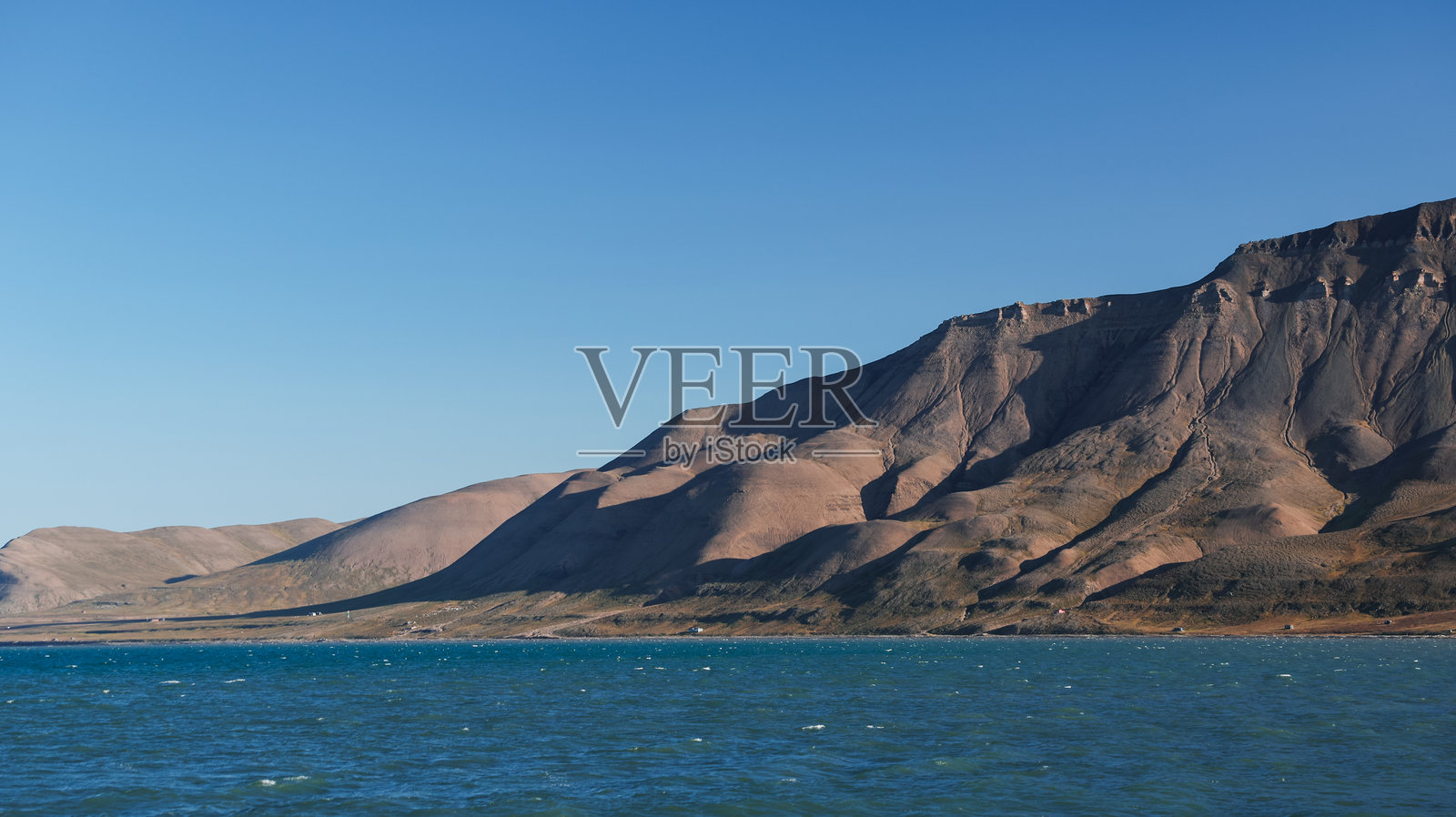 令人惊叹的斯瓦尔巴群岛海岸线在晴朗的蓝天和宁静的海面下展现出美丽的景色照片摄影图片