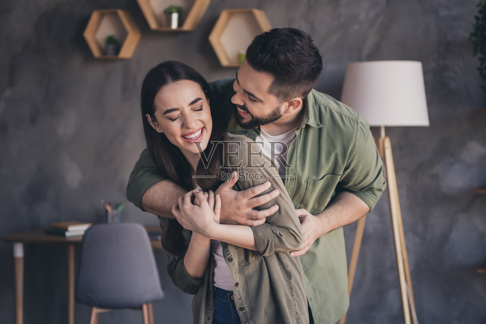 可爱的吸引人的男女穿着休闲衬衫,微笑着在室内公寓里享受共度时光。照片摄影图片