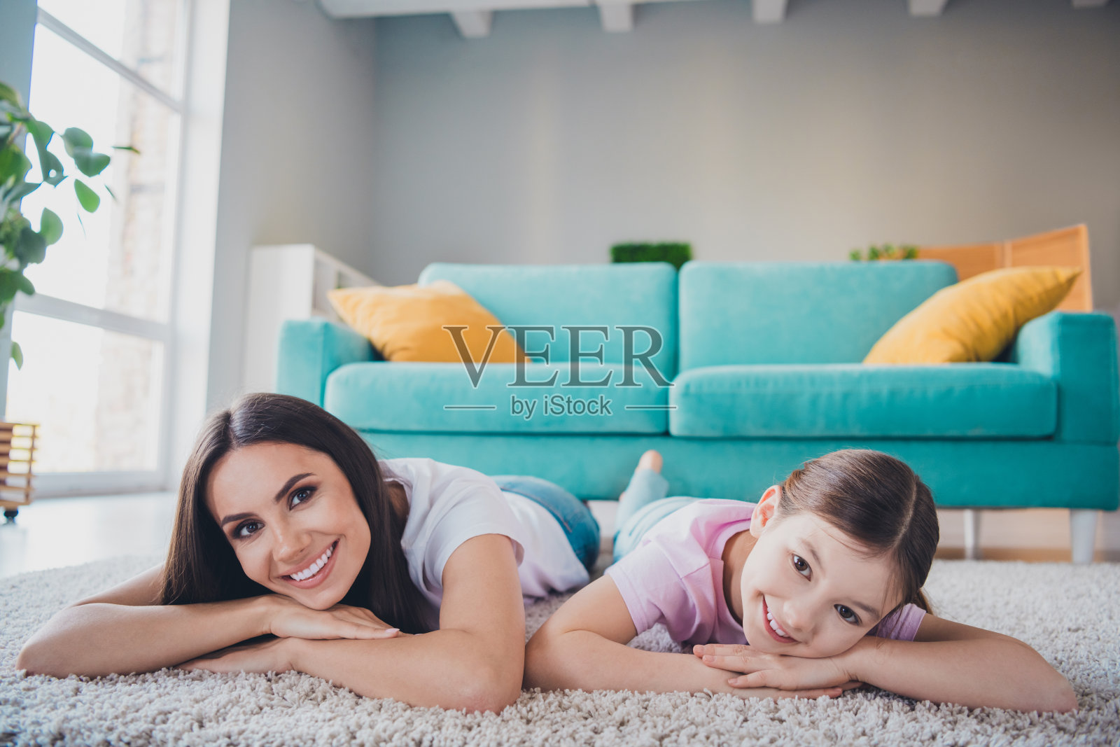 可爱的妈妈和女儿在公寓客厅的地板上一起度过周末的照片照片摄影图片