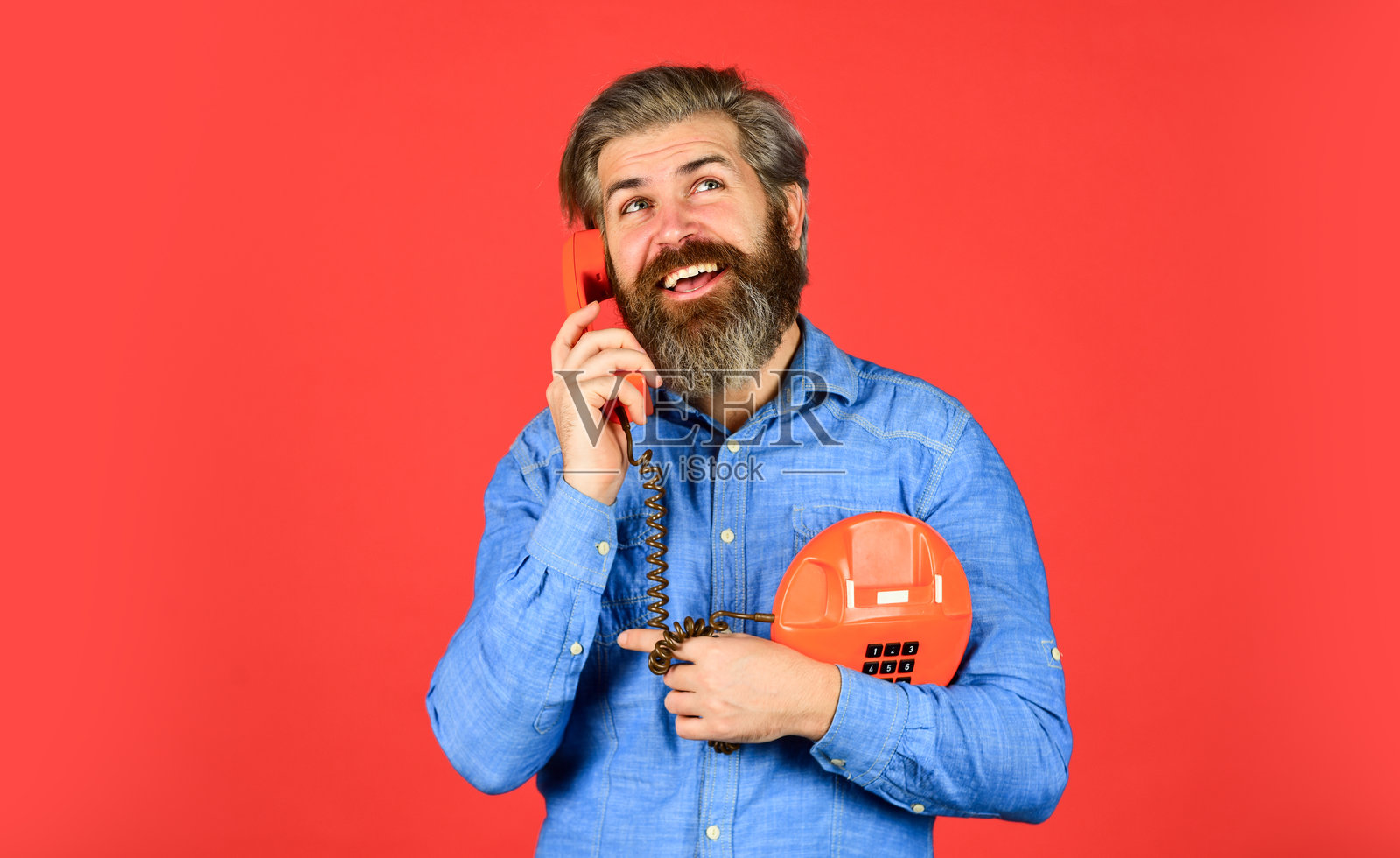 给你的品牌应有的关注。年轻男子在打电话。老派时尚的老年人使用电话。粗犷的男子在打电话。成熟的胡子男人在使用复古电话。现代生活中的复古科技。照片摄影图片